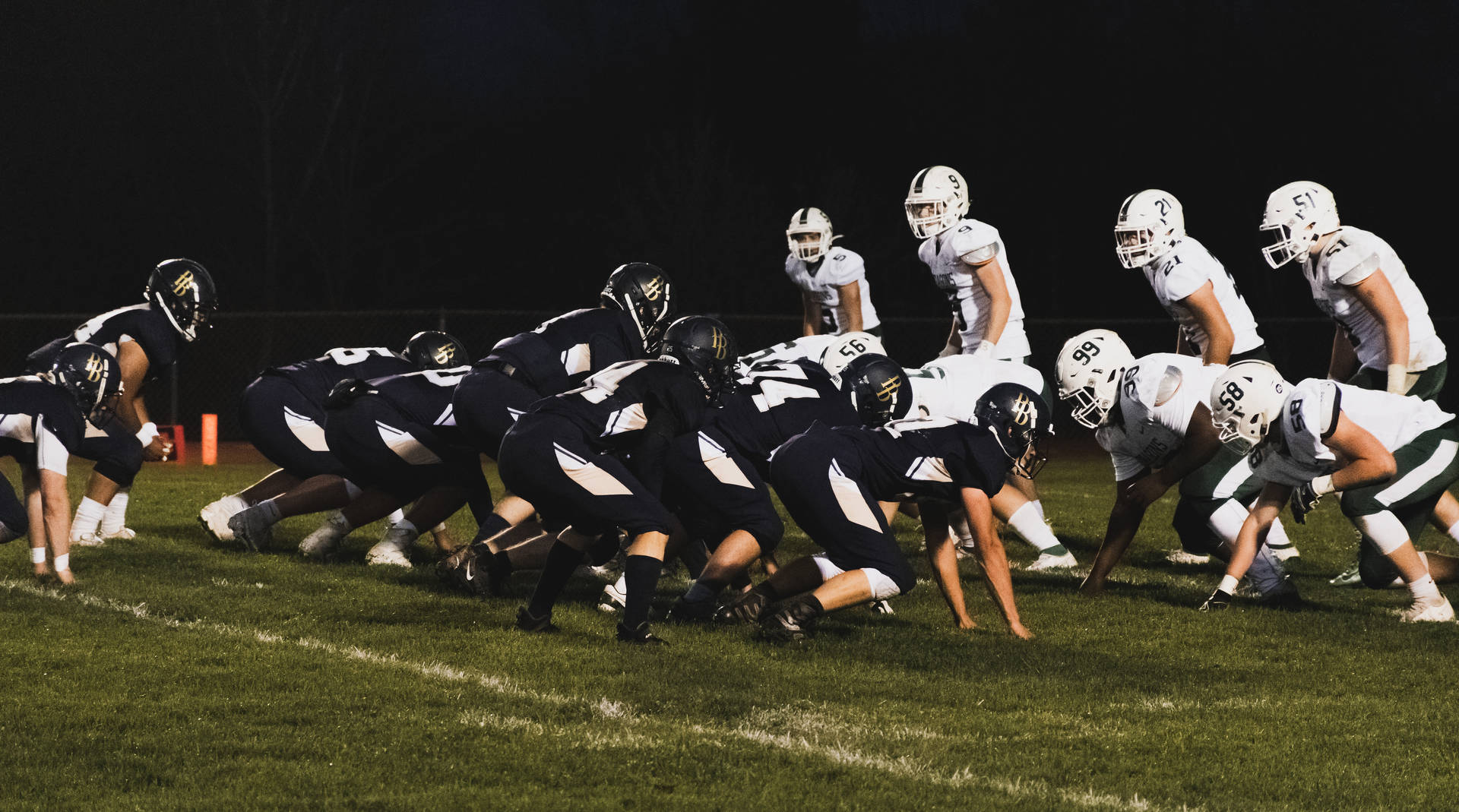 group of men in black and white football jersey shirt on green grass field during nighttime