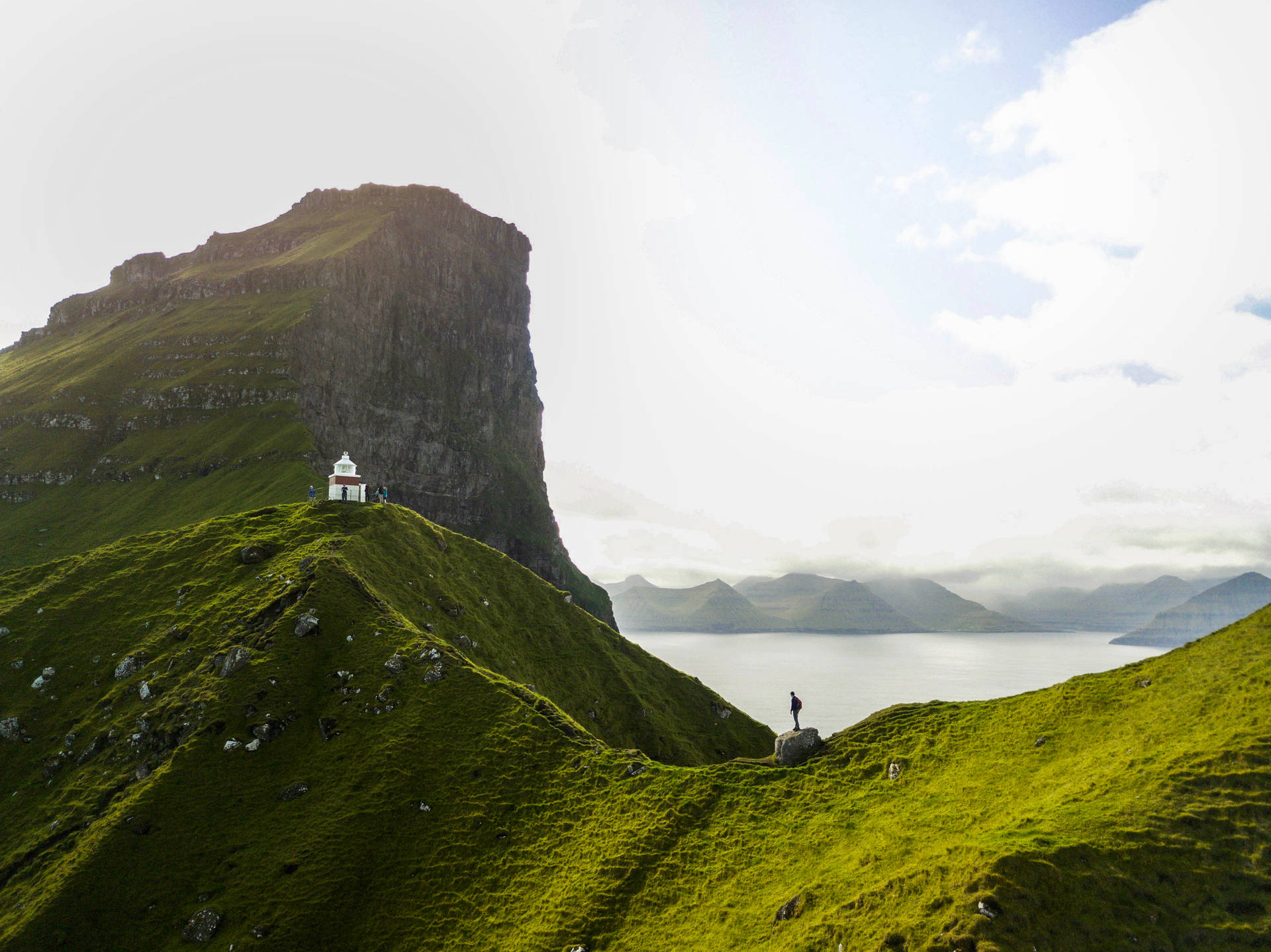 person standing on green mountain during daytime