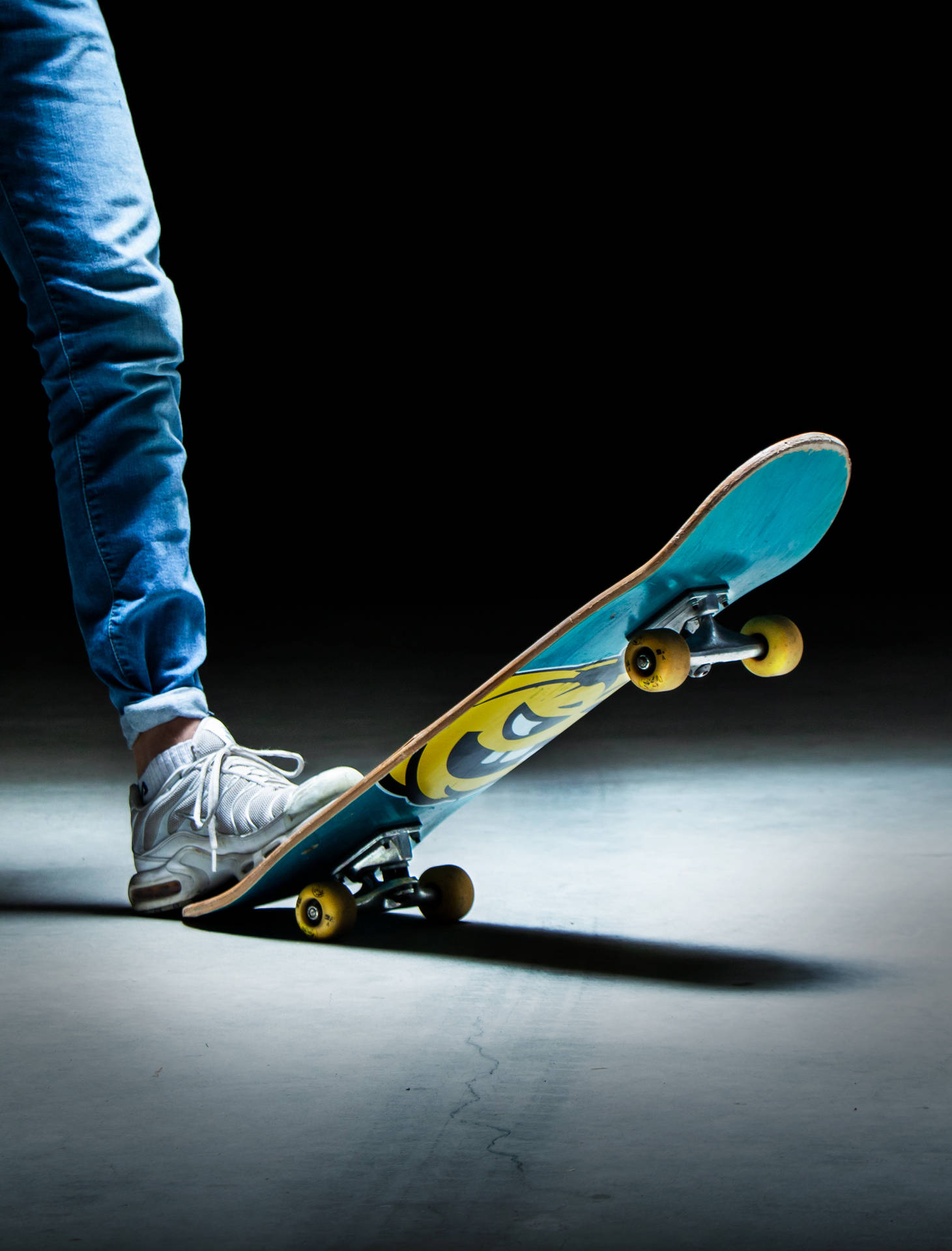 person in blue denim jeans and black and white nike sneakers riding skateboard
