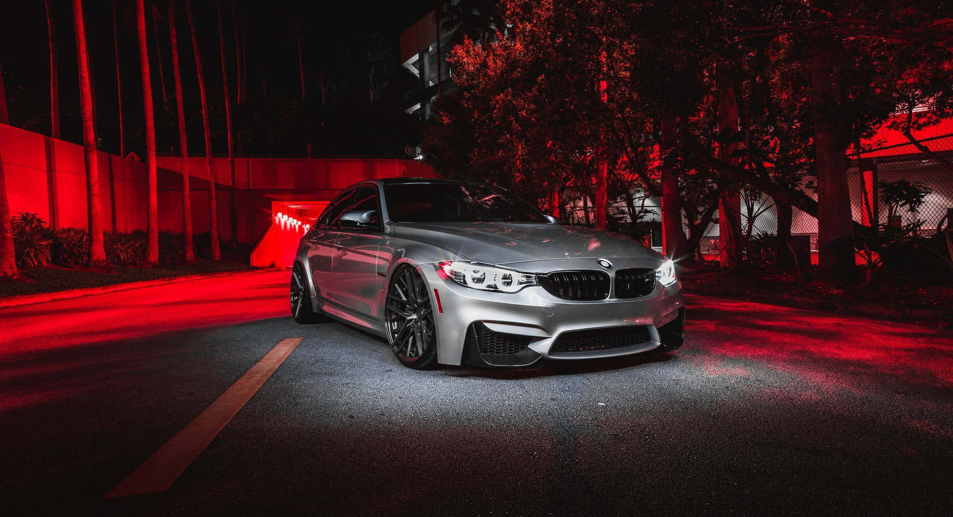 1080p M系列背景：紅色燈光下的2018灰色BMW M3 CS 壁紙 — 一輛銀色寶馬M3跑車在夜間黑暗的城市街道上，在強烈的紅色霓虹燈下閃閃發光。