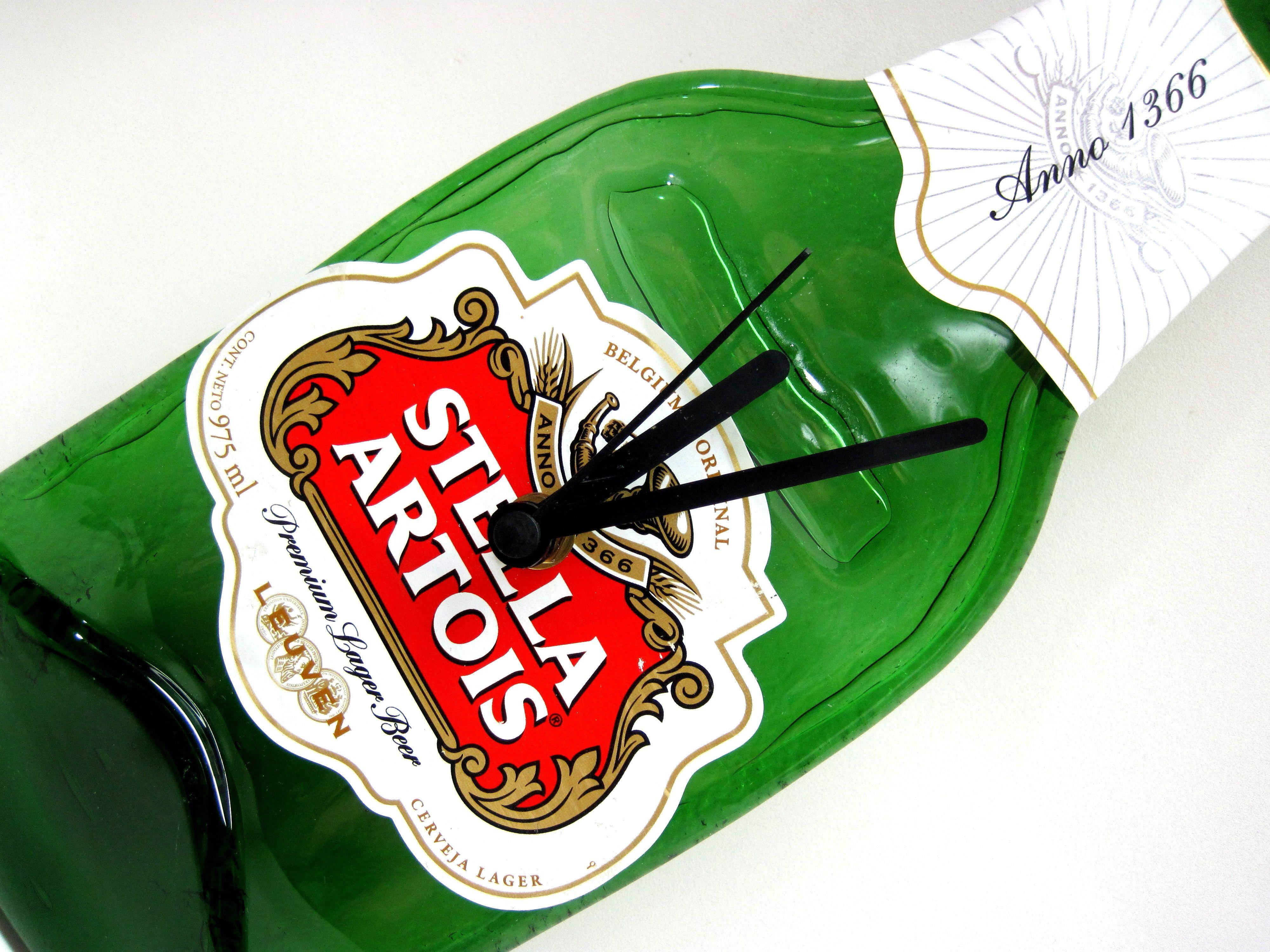 自 1366 年以來的比利時啤酒 Stella Artois 壁紙 — 一個綠色Stella Artois啤酒瓶被重新用作掛牆鐘，帶有黑色指針，背景為白色。