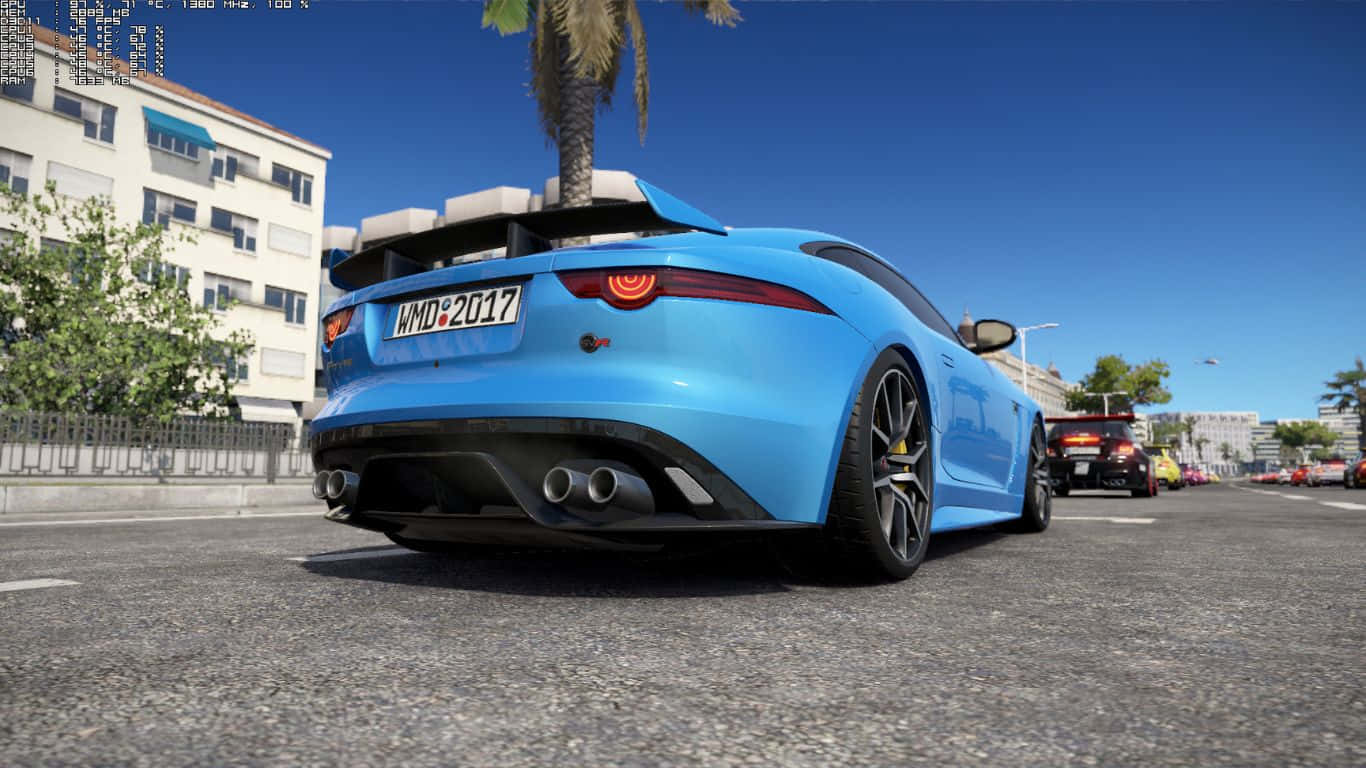1366x768 Project Cars 2 2018 賈吉爾 F-TYPE SVR 背景 壁紙 — 一輛充滿活力的藍色跑車，帶有後擾流板和雙排氣管，停在陽光明媚的城市街道上，天空湛藍。