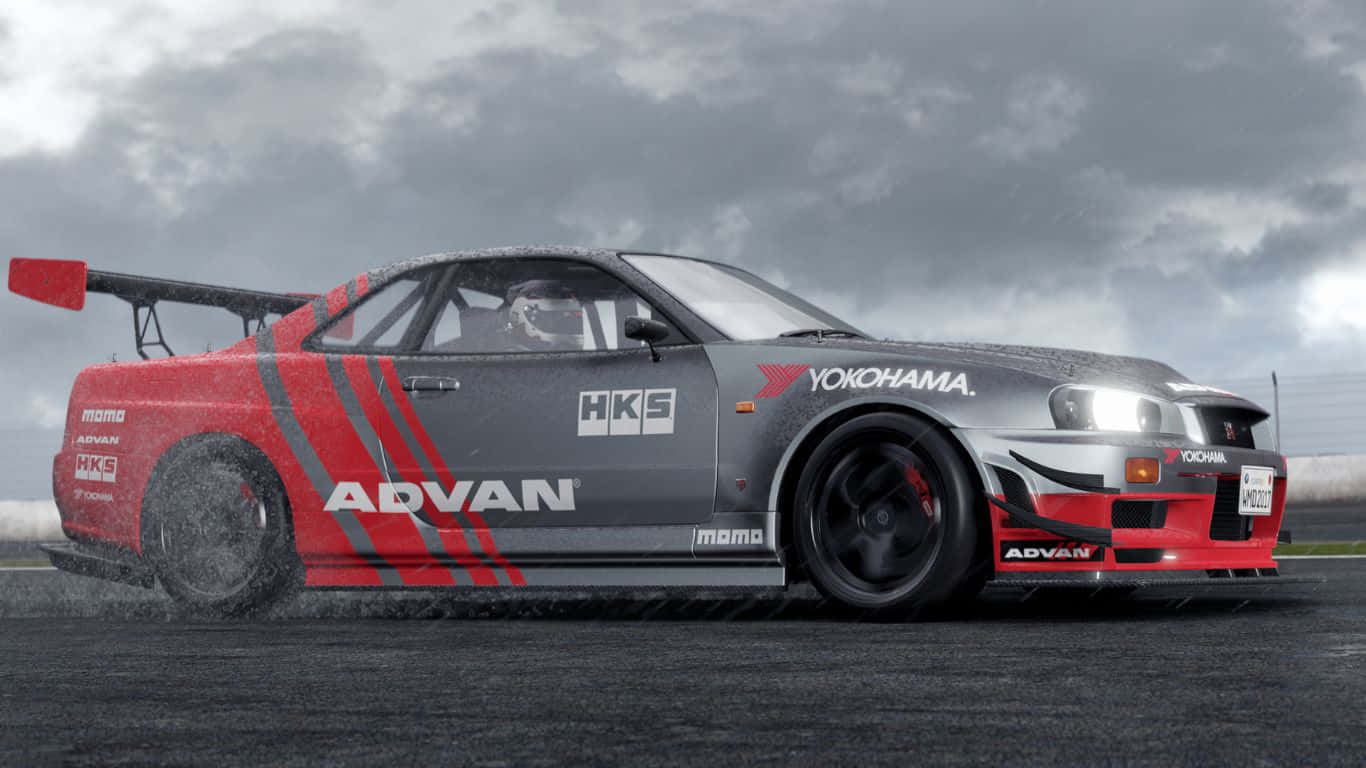 1366x768 Project Cars 2 Nissan Skyline GT-R 背景 壁紙 — 一輛帶有贊助商貼紙的紅灰色漂移車在暴風雨天空下的潮濕賽道上側滑疾馳。