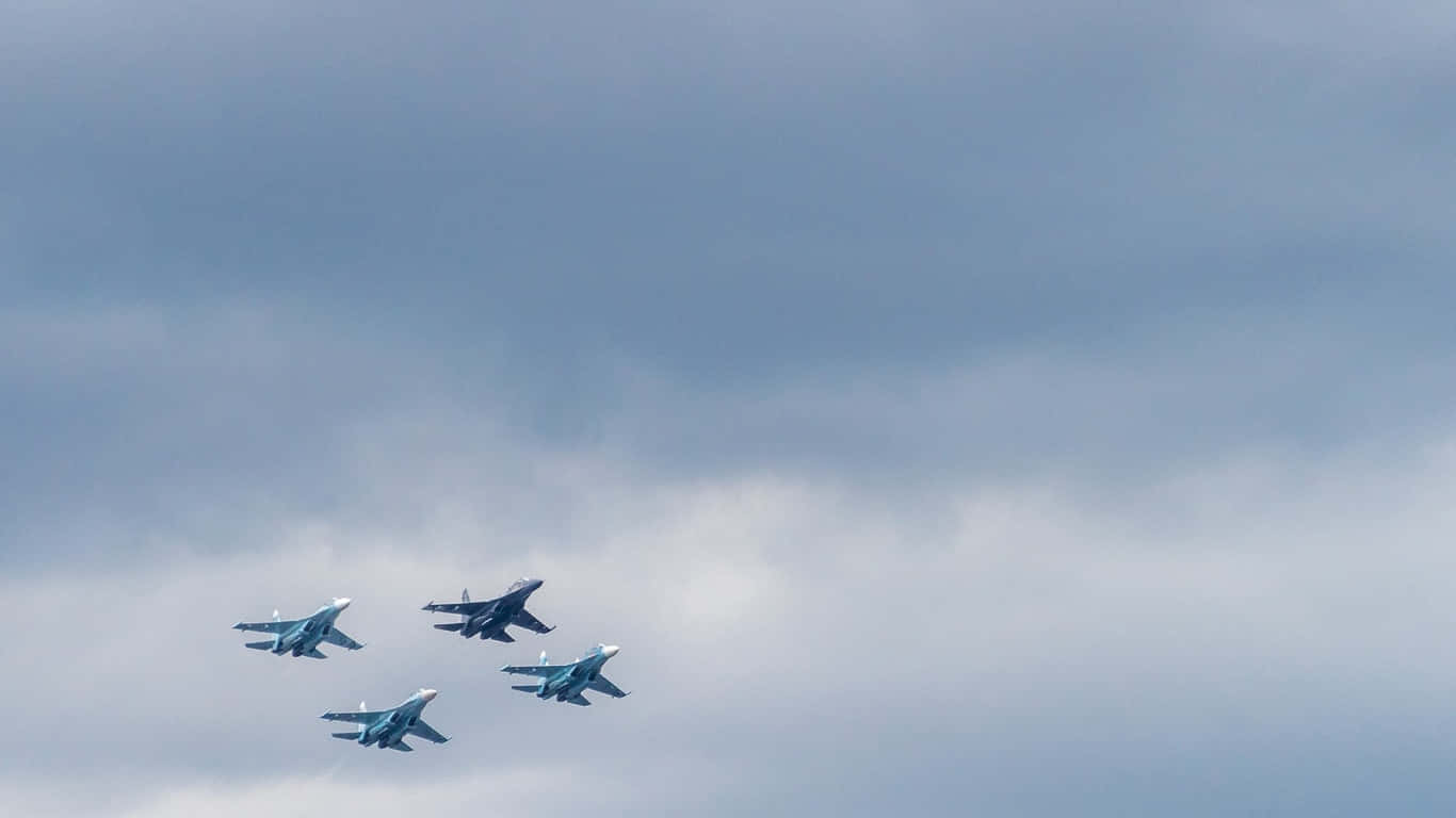 1366x768 巨型客機背景：四指編隊飛行 壁紙 — 四架戰鬥機在戲劇性的多雲天空中緊密編隊飛行。