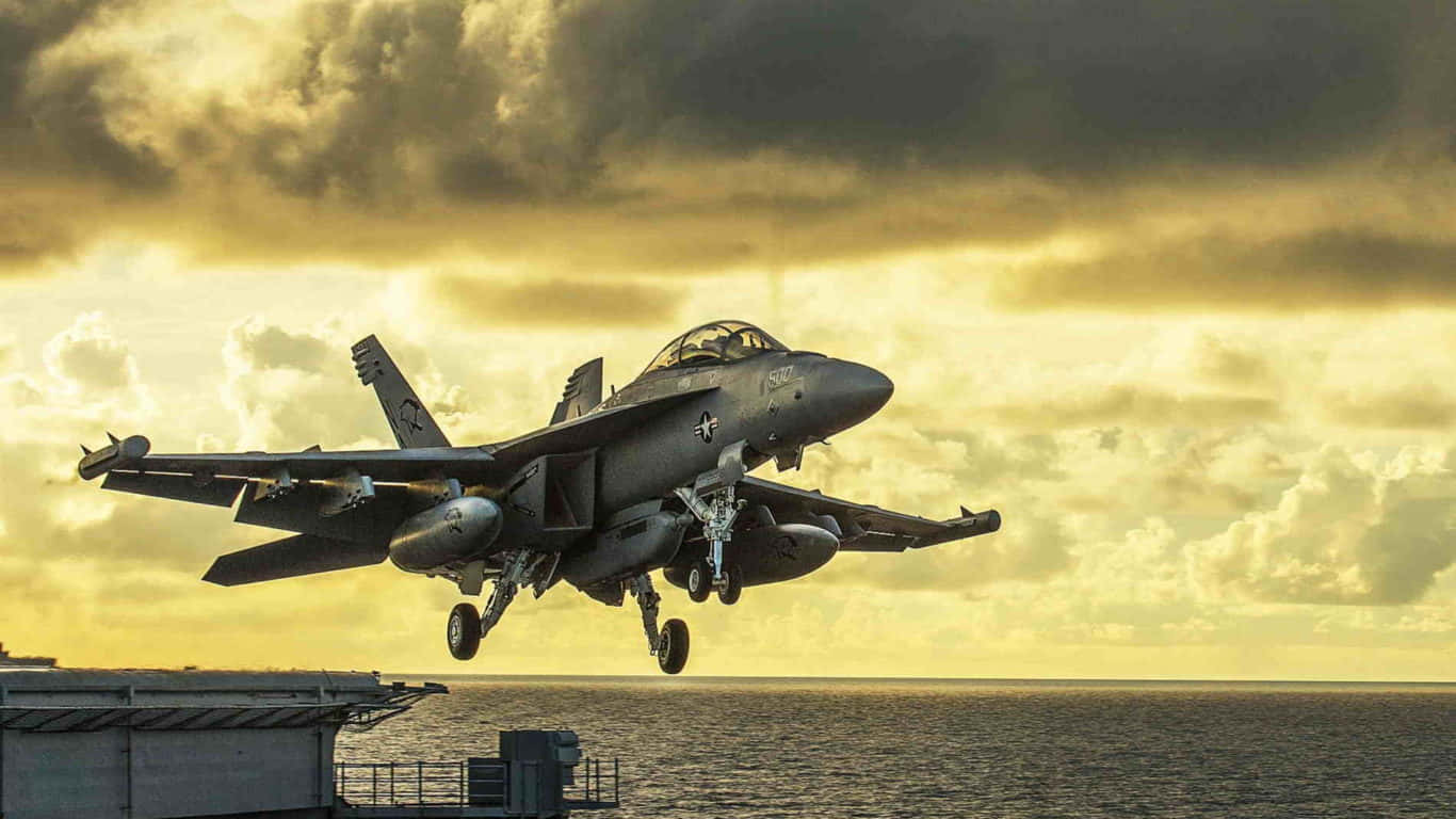 1366x768 巨型客機背景：海軍艦載跑道 壁紙 — 一架灰色戰鬥機在日落時從航空母艦上起飛，下方是金色雲彩和海洋。