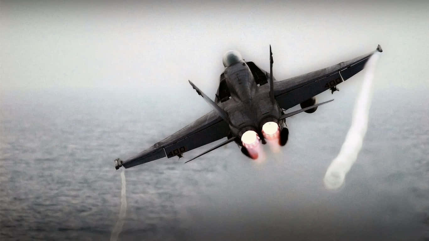 1366x768 巨型客機背景 露水尾跡 壁紙 — 一架戰鬥機在海洋水面上低空飛過，後燃器燃燒，留下凝結尾跡。