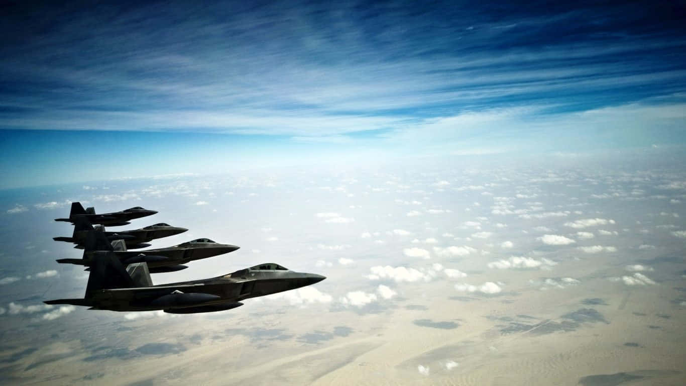 1366x768 巨型客機背景配F-22猛禽戰機 壁紙 — 四架戰鬥機在動感藍天下，以緊密編隊飛越廣闊的沙漠景觀。