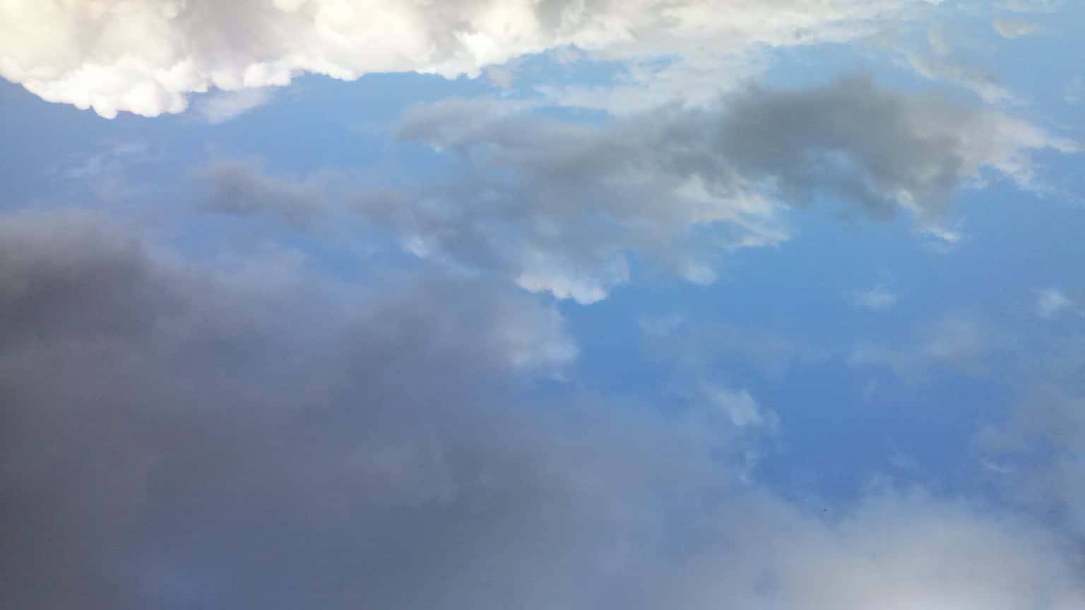 雲-14 壁紙 — 動態的天空，蓬鬆的白雲在充滿活力的藍色畫布上飄移。