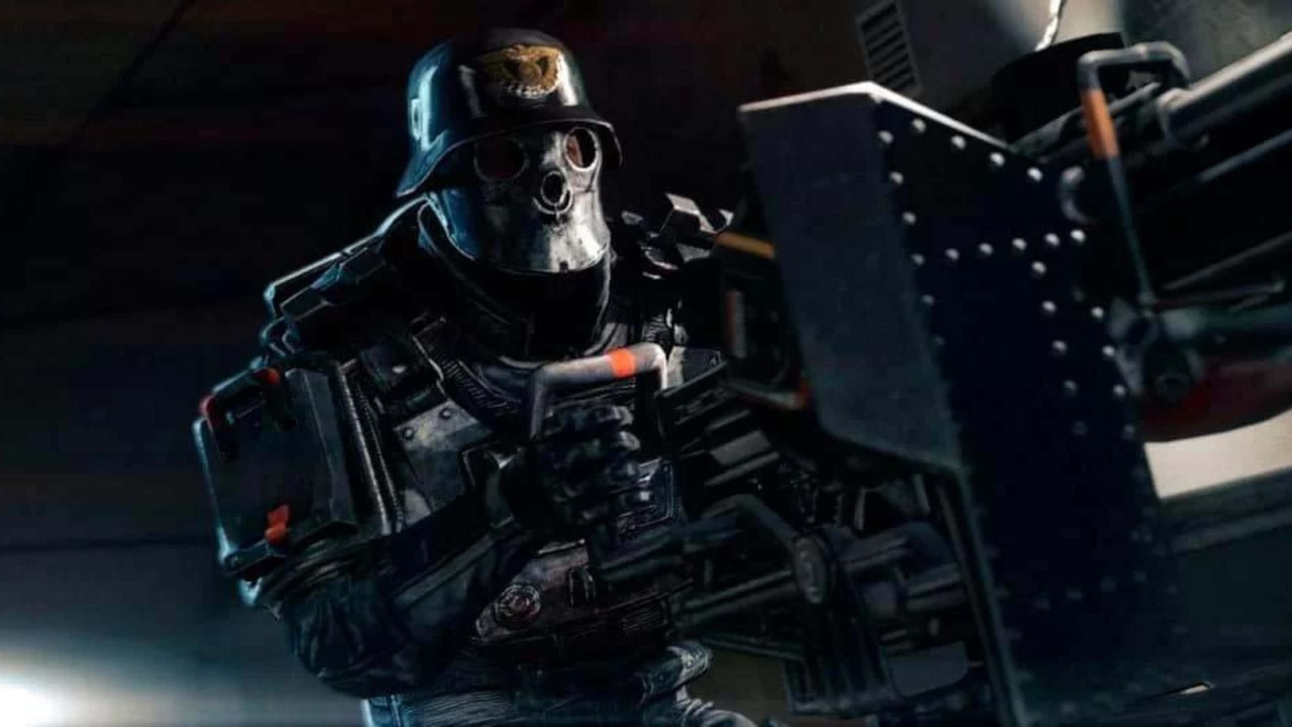 以 1440p 高清體驗 Wolfenstein II 的動作劇情 壁紙 — 一名身穿深色戰術裝備和骷髏面具的士兵在昏暗的工業環境中瞄準重型武器。