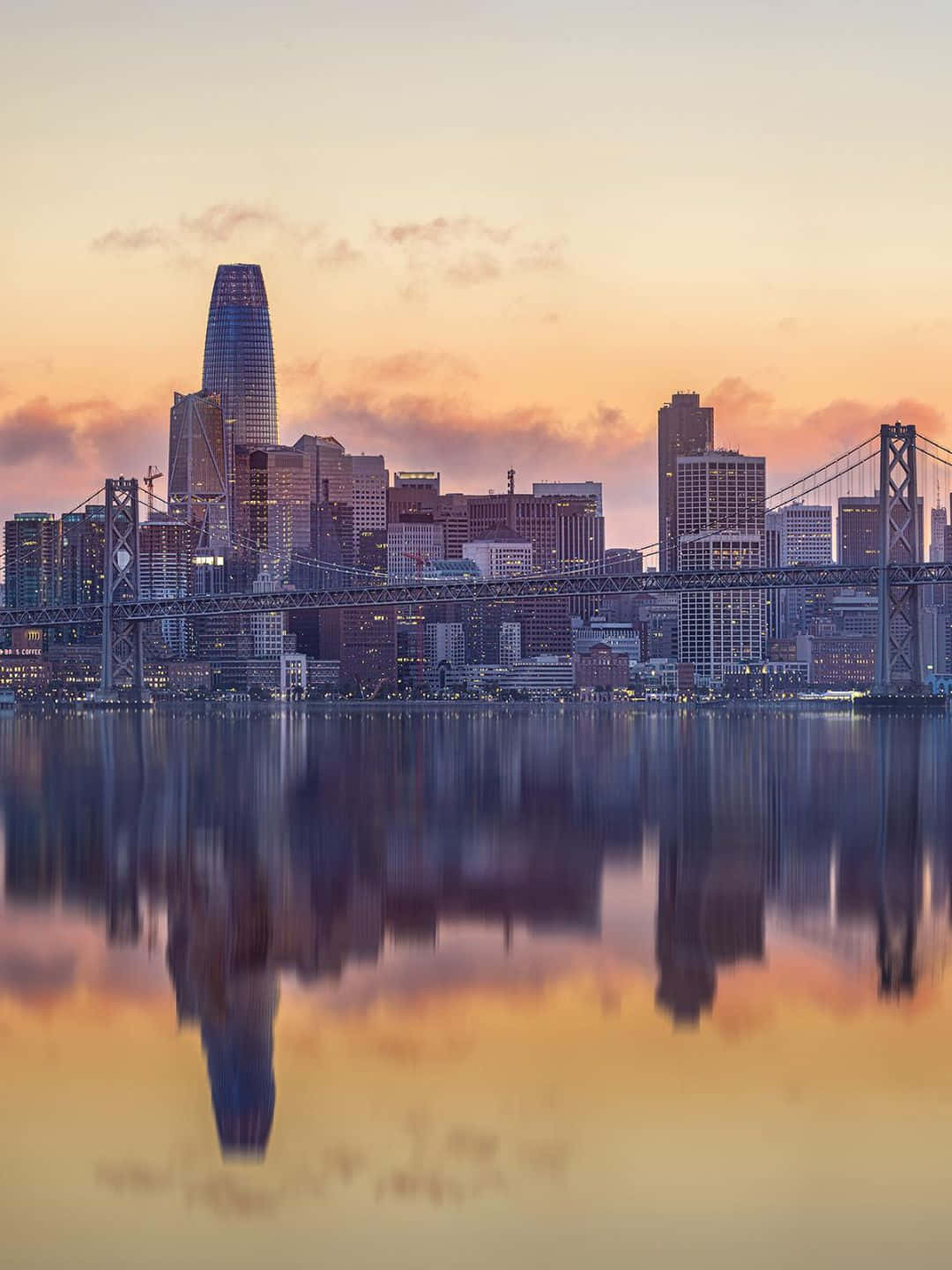 1440p 聖弗朗西斯科 Salesforce Tower 壁紙 — 三藩市日落時分天際線，金門大橋倒映在橙紫色天空下的平靜水面上。