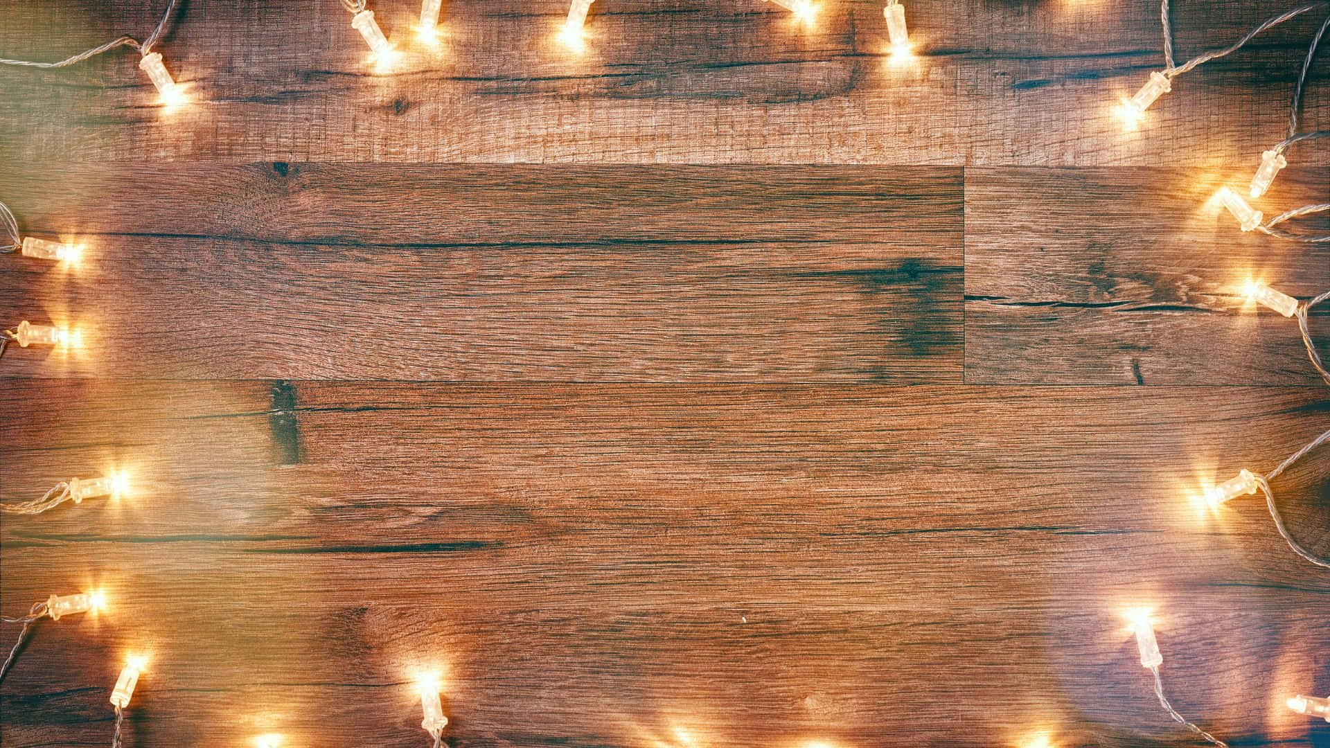 1920 X 1080 桌布 壁紙 — 溫暖的串燈在質樸的木質表面邊緣柔和地發光，營造出舒適溫馨的氛圍。