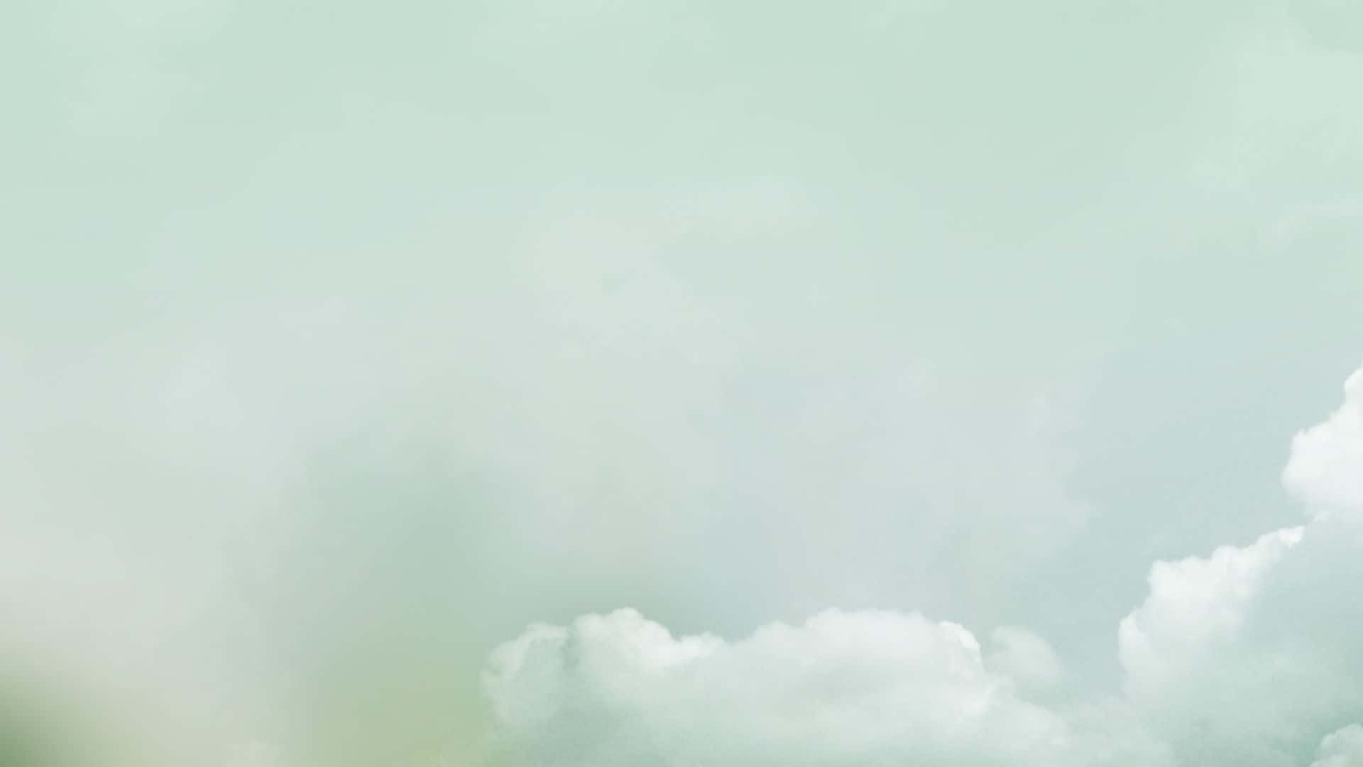 粉綠色天空，柔和白色雲朵平靜地飄動。