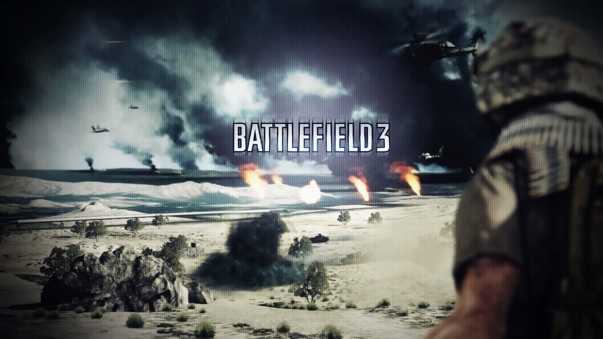 1920x1080《Battlefield 3》戰區背景 壁紙 — 一名身穿沙漠作戰裝備的士兵，在風暴天空下，於戰火摧殘的乾旱戰場上觀看爆炸和直升機。