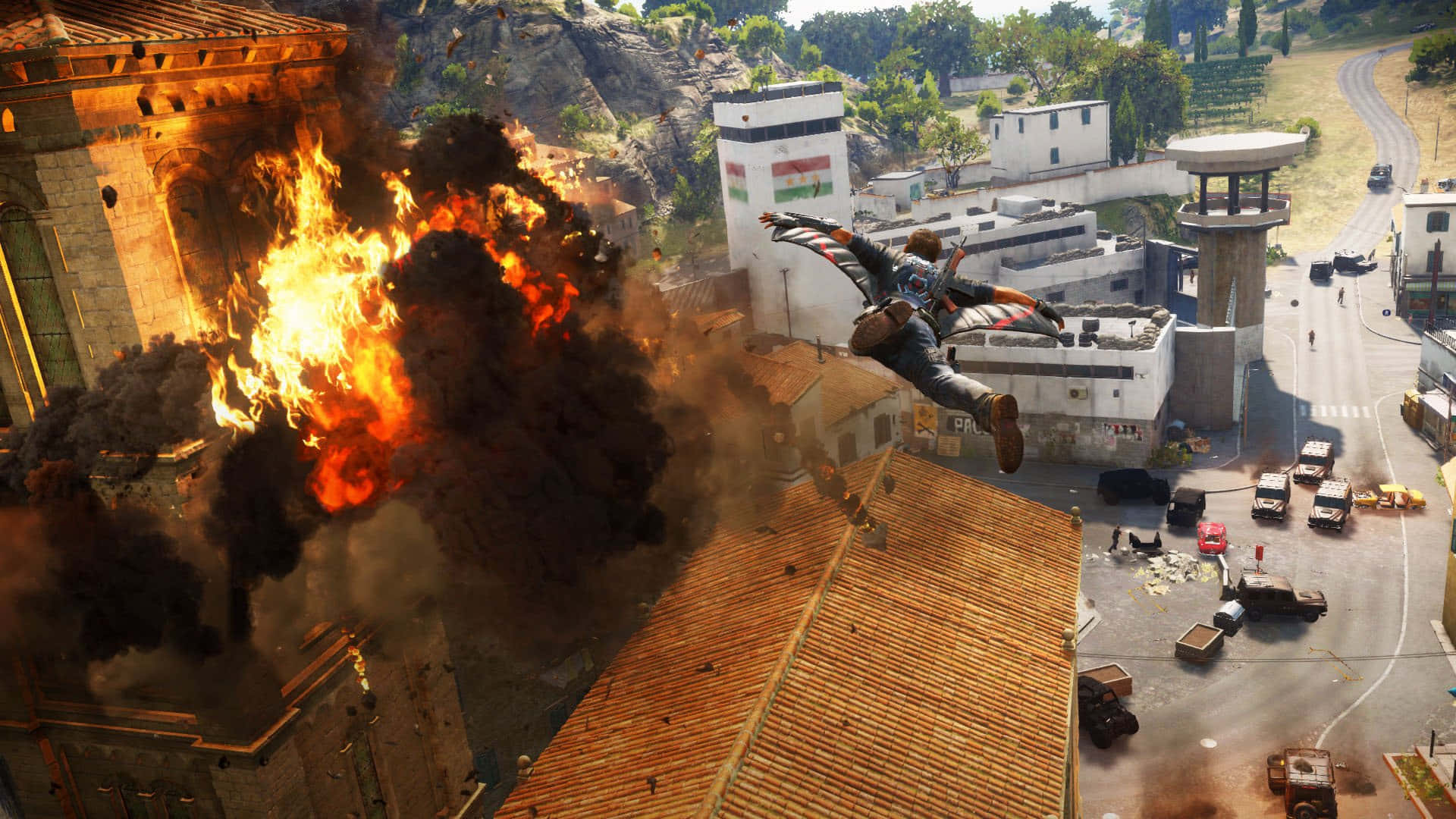 1920x1080 Just Cause 4 黑煙背景 壁紙 — 一個角色在混亂的城市戰區中，飛越一棟燃燒的建築物，伴隨著爆炸和煙霧。