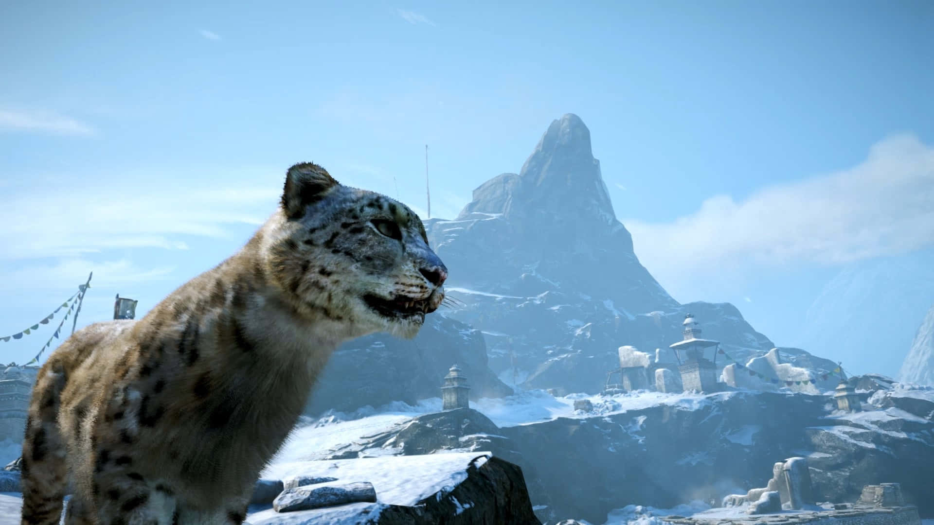 1920x1080《孤島驚魂4》背景：Felidae 壁紙 — 一隻雪豹棲息在積雪的懸崖上，俯瞰著一個有經幡和石砌佛塔的山地景觀，天空清澈湛藍。