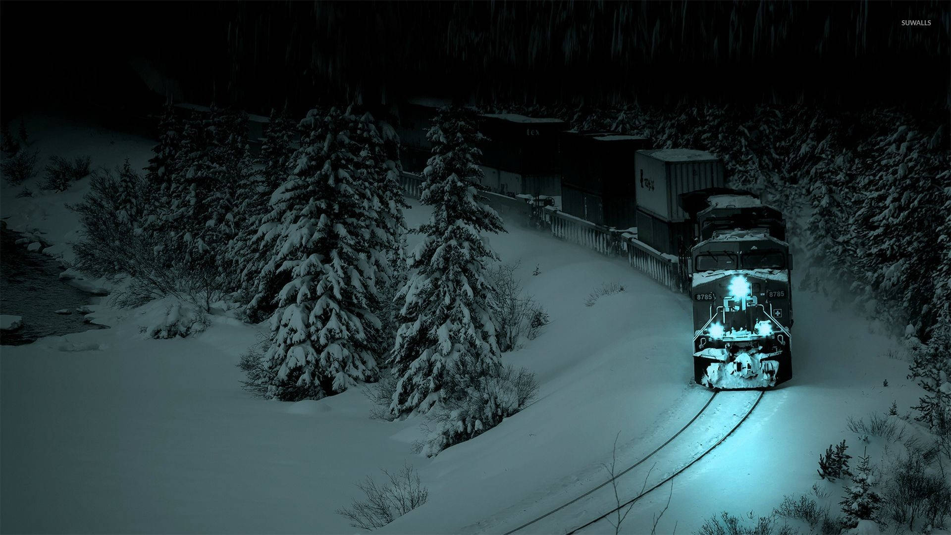 貨運火車在夜間穿過白雪覆蓋的森林，車頭燈閃爍。