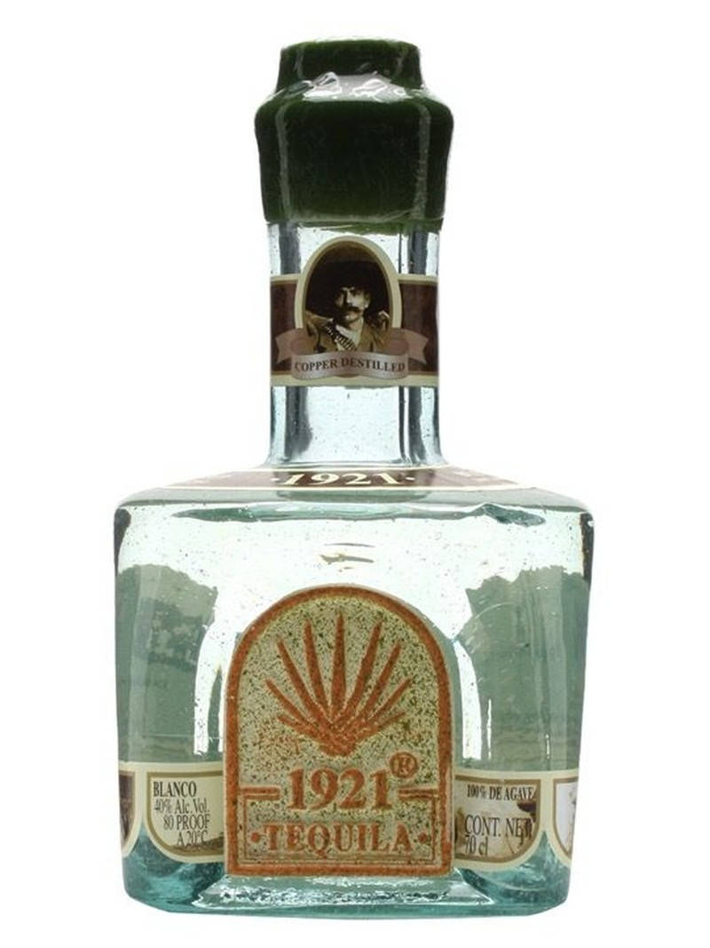 1921 白色龍舌蘭酒精緻瓶身 壁紙 — 一個透明玻璃瓶裝的1921 Blanco龍舌蘭酒，帶有綠色瓶蓋和復古標籤，上面有男士肖像和龍舌蘭植物。