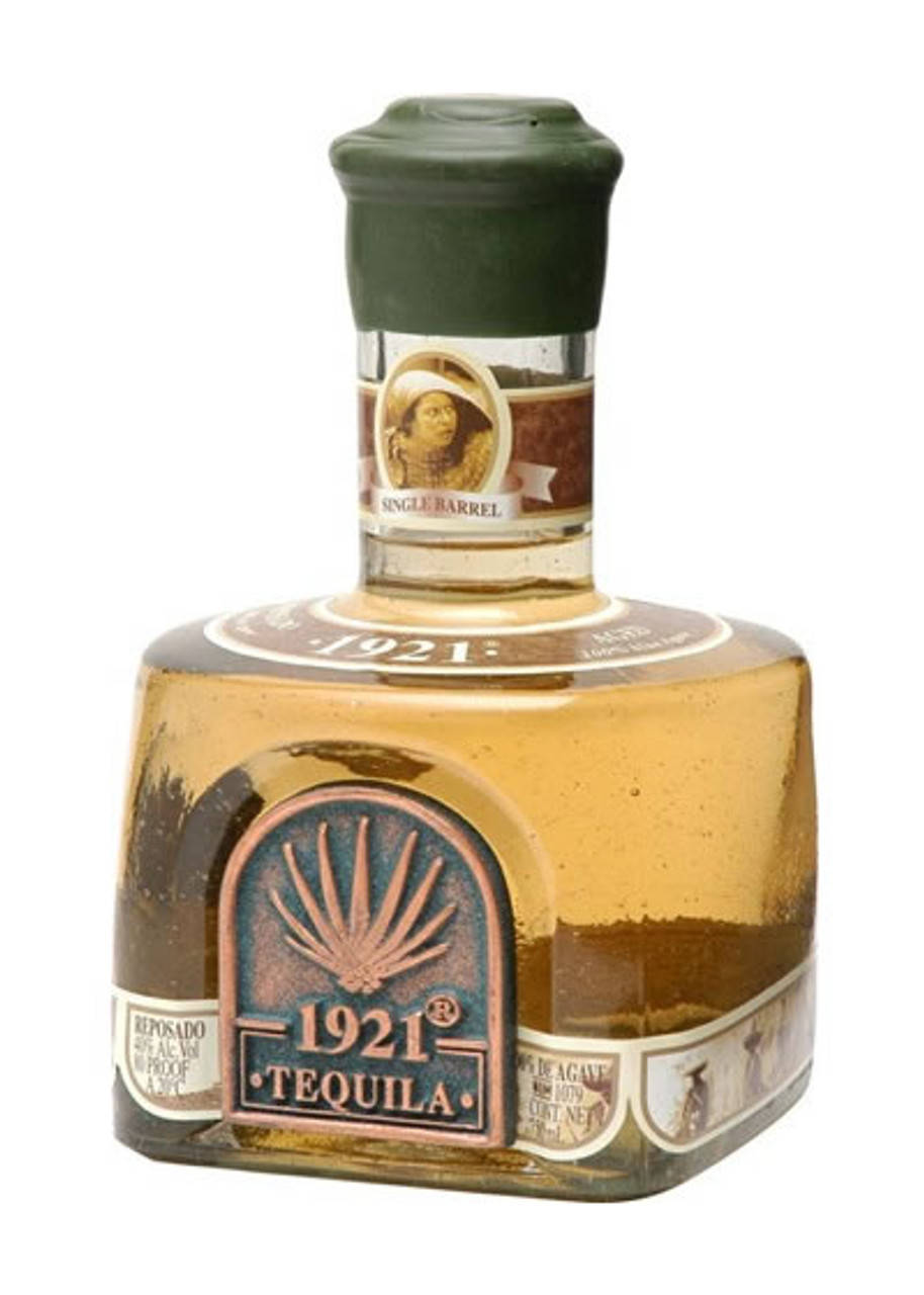 一瓶帶有復古標籤和琥珀色液體的1921 Tequila Reposado。