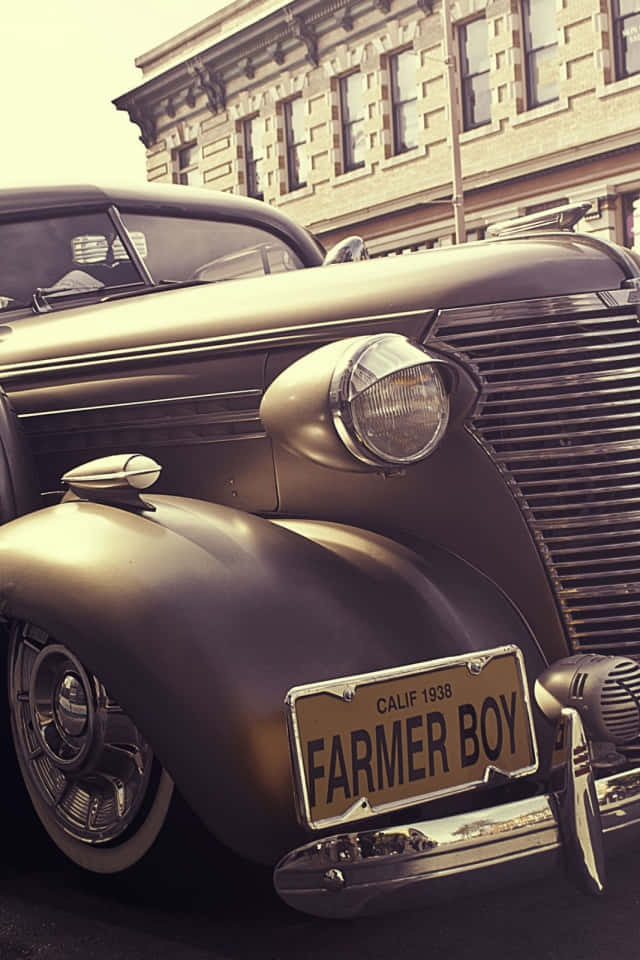 1938年雪佛蘭經典復古車 壁紙 — 一輛1938年復古雪佛蘭，掛著「FARMER BOY」車牌，在溫暖陽光下於石建築旁閃閃發光。