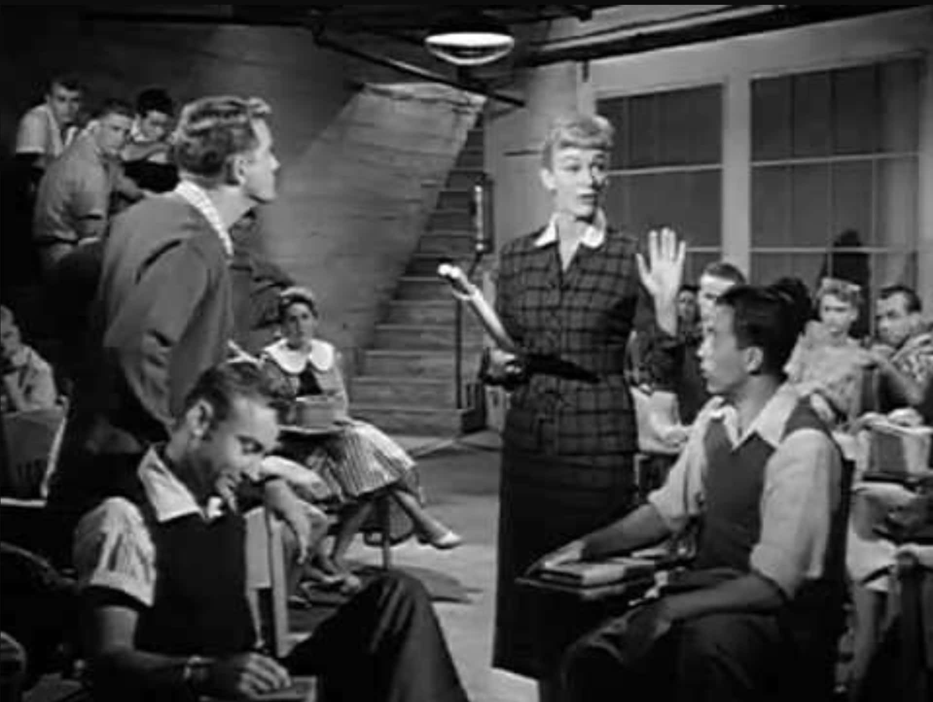 Richard Crenna 桌布 壁紙 — 1950年代的黑白課室場景，老師向坐在書桌前的學生做手勢。