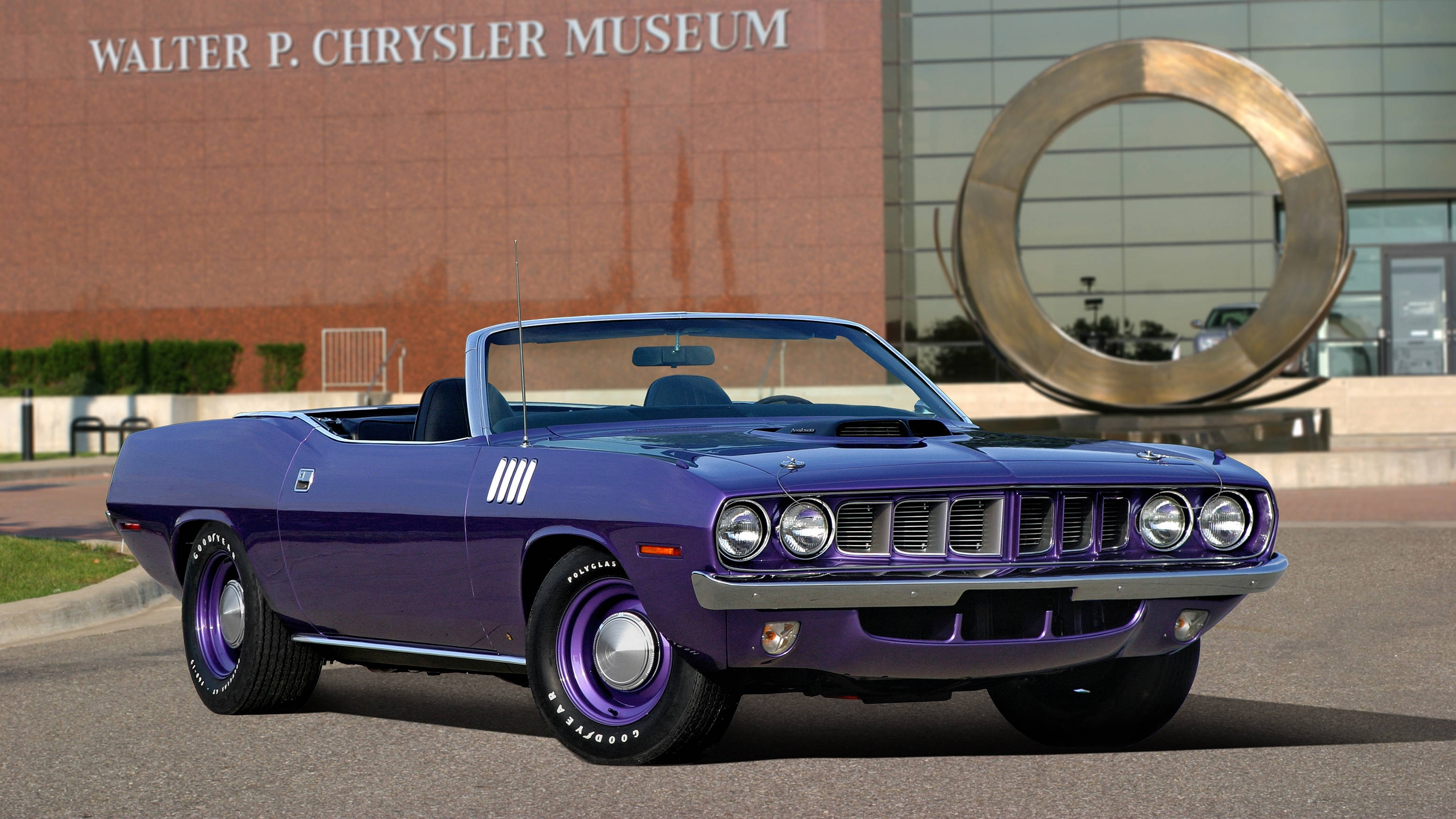 1971年款深紫Plymouth Barracuda敞篷車 壁紙 — 一架充滿活力的紫色經典開篷肌肉車，在明亮的日光下自豪地停泊在 Walter P Chrysler 博物館前。