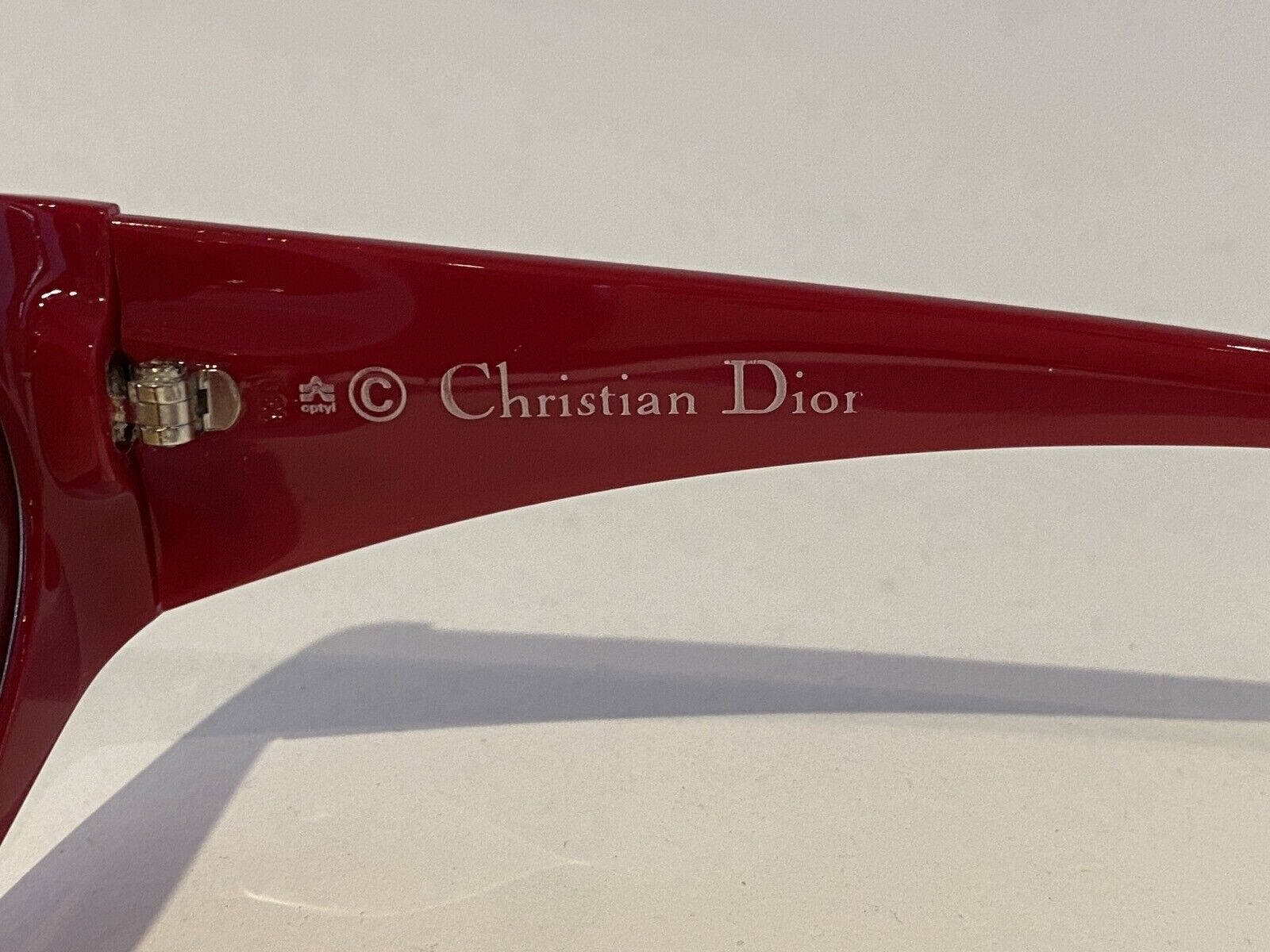 1980年代NOS復古Christian Dior 2348 10太陽眼鏡 壁紙 — 特寫：光滑紅色Christian Dior太陽眼鏡臂，帶銀色標誌，置於純白背景上。