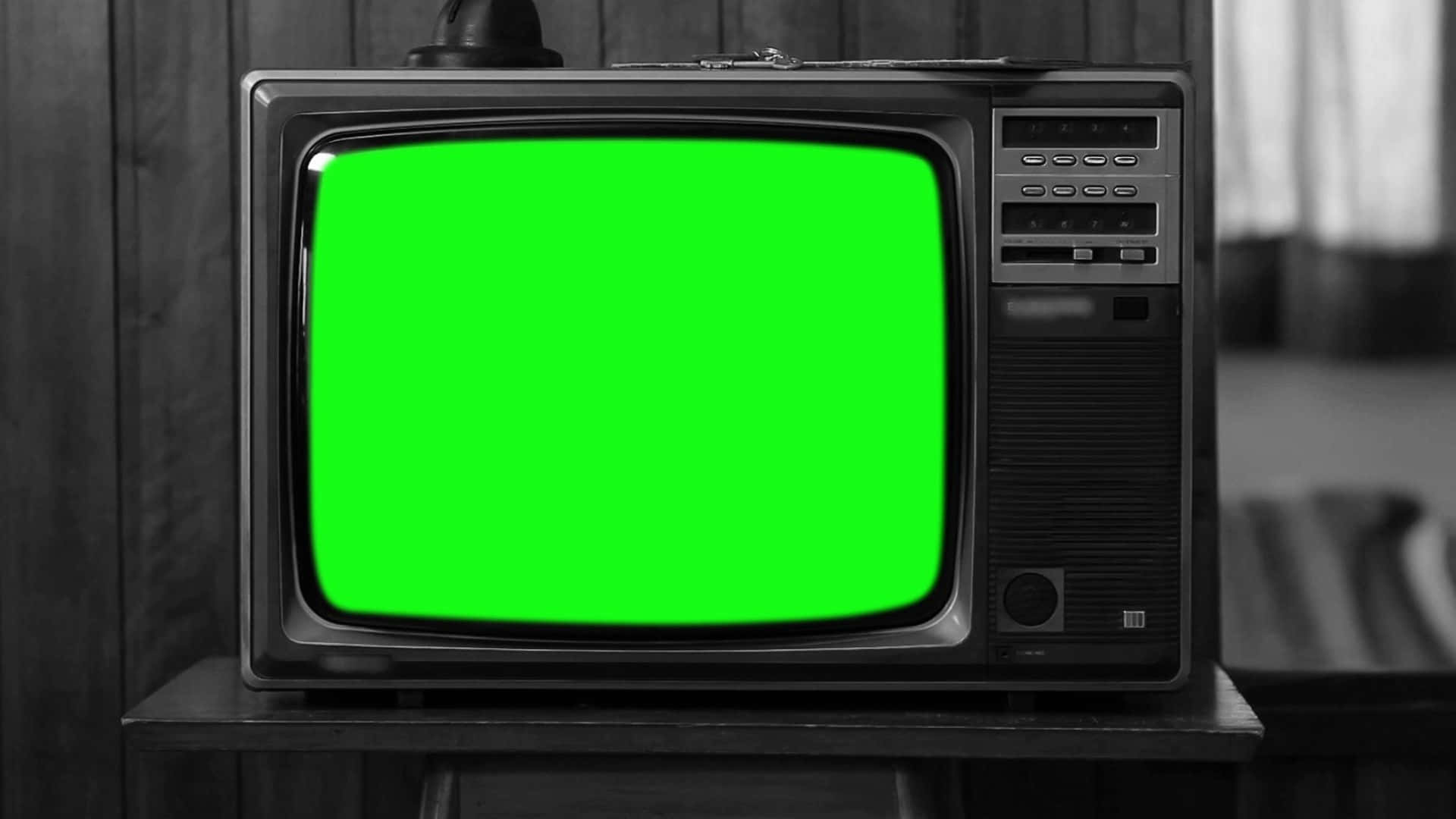 1980年代的經典音樂 壁紙 — 復古CRT電視機，帶有亮綠色屏幕，放置在木製支架上，背景為單色木牆。