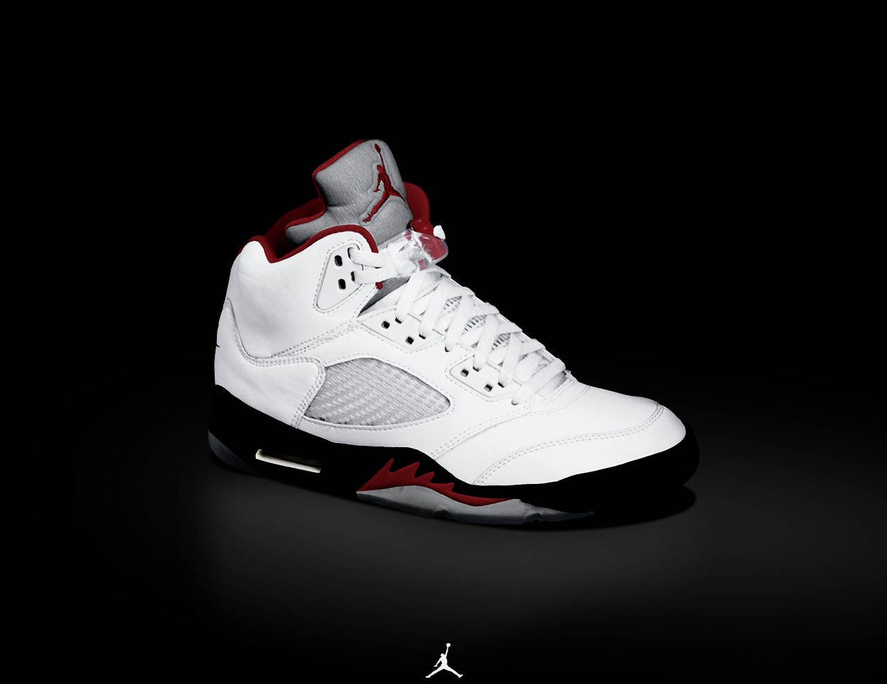 白色Jordan 5運動鞋，帶有紅色和黑色細節，背景為黑色