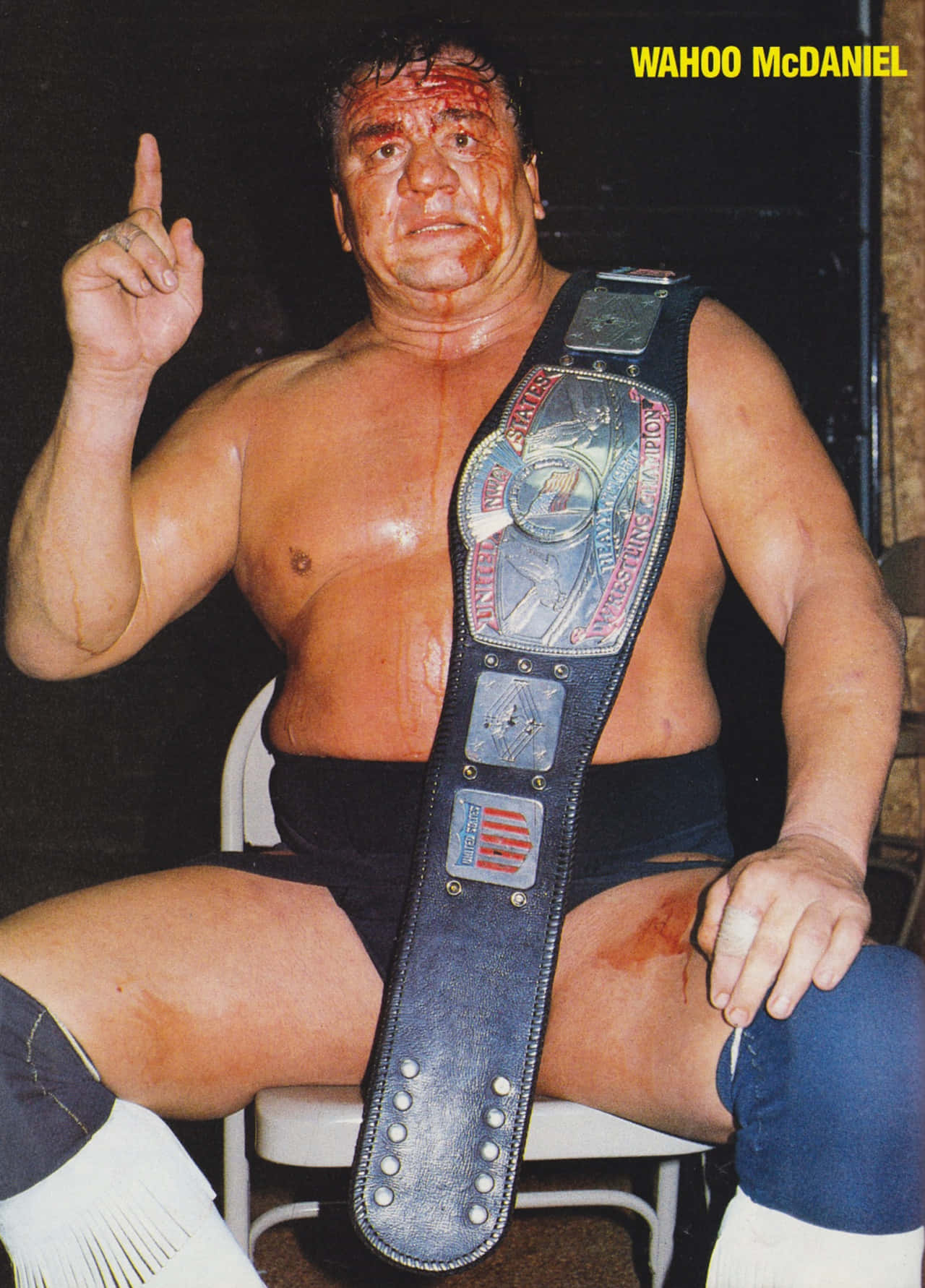 1985年美洲原住民重量級冠軍Wahoo McDaniel照片 壁紙 — Wahoo McDaniel 坐在椅子上，戴著冠軍腰帶，臉上和身上有血。