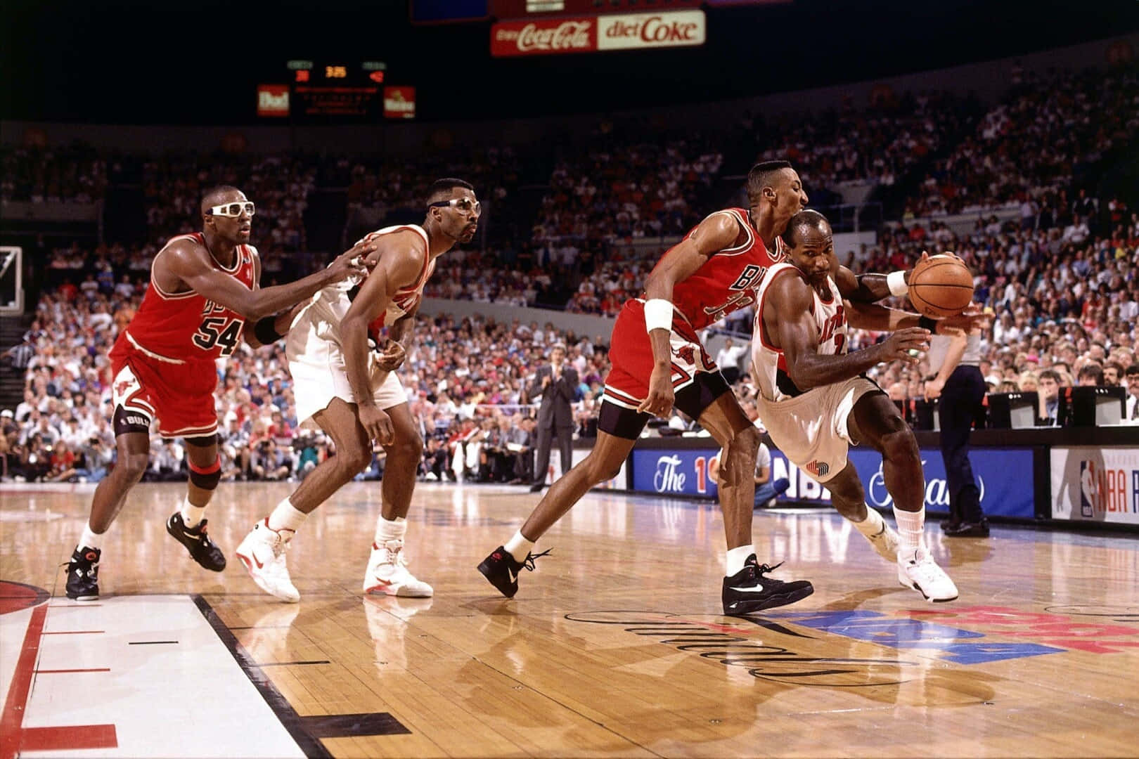 1992年NBA總決賽 克萊德·德雷克斯勒對陣公牛隊 壁紙 — 四名籃球運動員在明亮的場館燈光下，於一場高能量的NBA比賽中激烈爭奪球權。