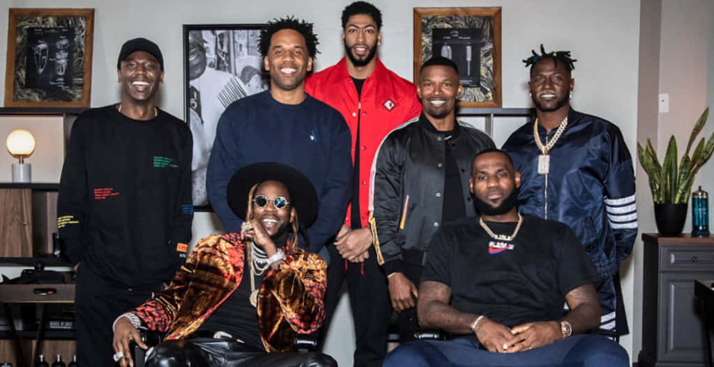 2 Chainz 紅毯上展現精緻造型 壁紙 — 七個微笑嘅男人著住時尚街頭服飾，喺一個有裱框藝術品同植物嘅現代客廳入面一齊擺甫士。