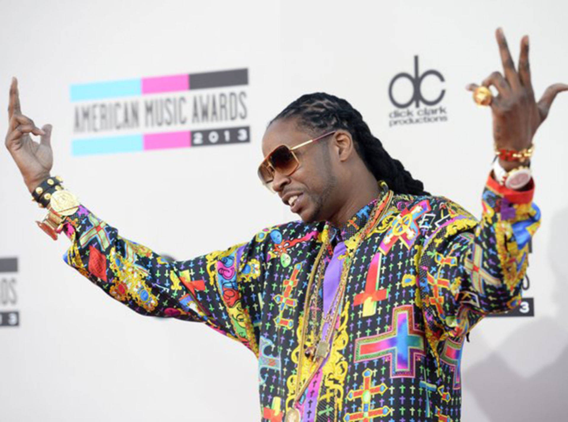 2 Chainz出席2013年美國音樂獎 壁紙 — 一名身穿鮮豔圖案外套和太陽眼鏡的男子在2013年美國音樂獎紅地毯上擺姿勢。