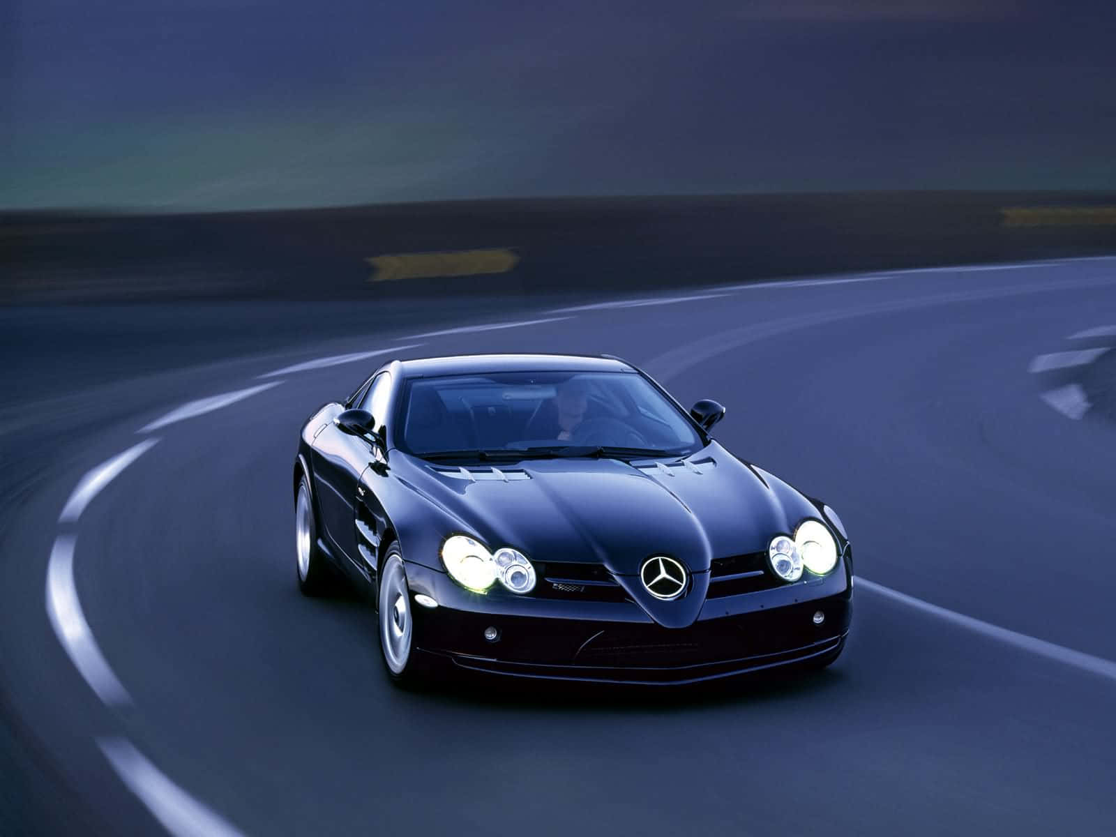 黑色 Mercedes SLR McLaren 在夜間賽道上飛馳。