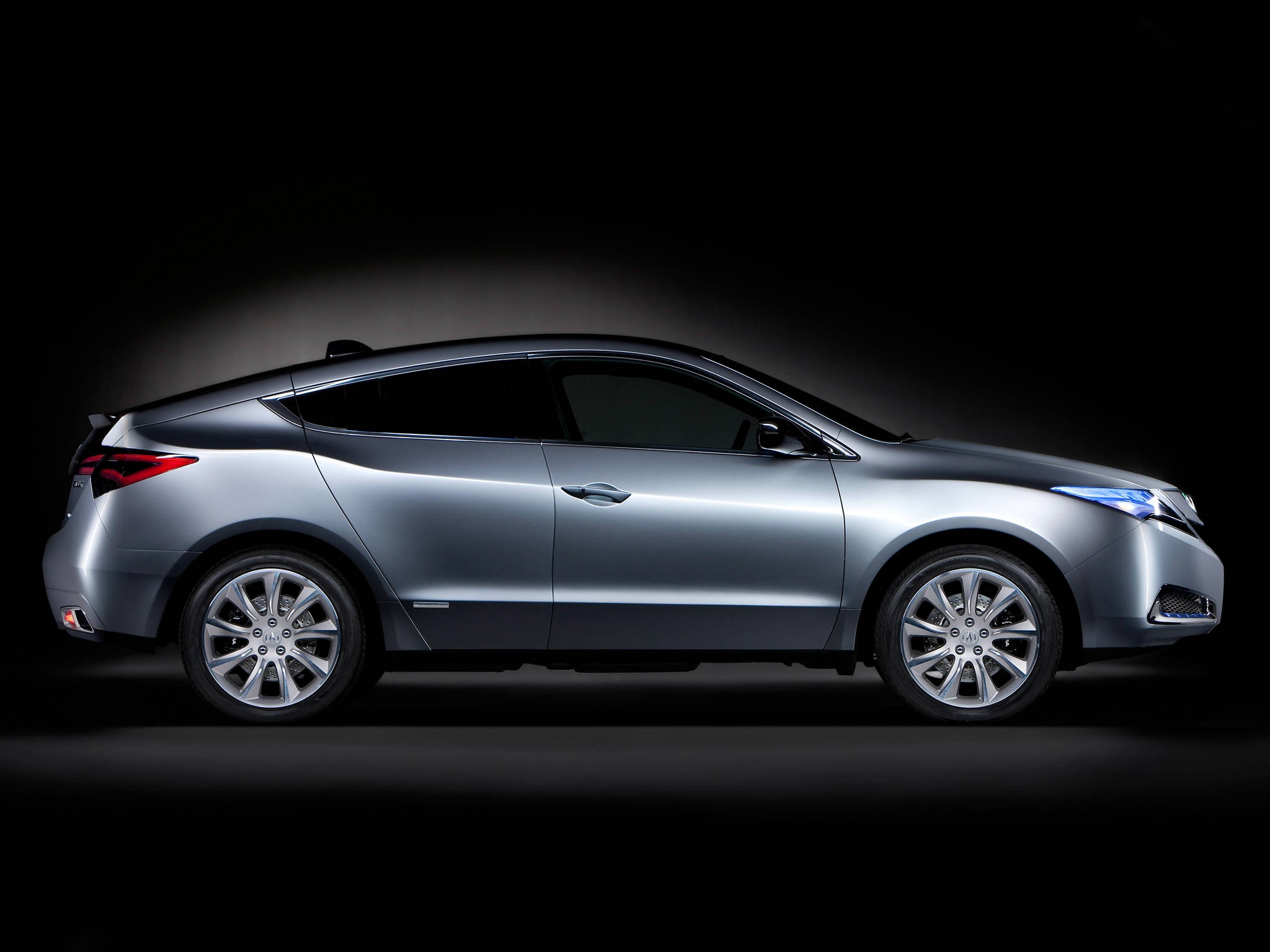 2009款Acura ZDX側面視圖 壁紙 — 一輛時尚的銀色轎跑車在純黑背景下於攝影棚燈光中閃耀，展示其空氣動力學曲線和合金輪圈。
