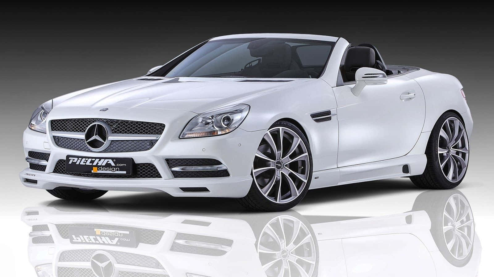 白色 Mercedes-Benz SLK 開篷跑車，配備訂製輪圈，在反光攝影棚地板上。