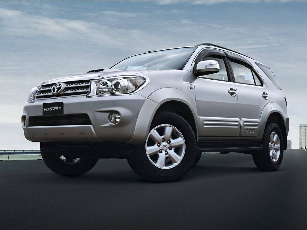 銀色豐田 Fortuner SUV 在道路上，背景為陰天。