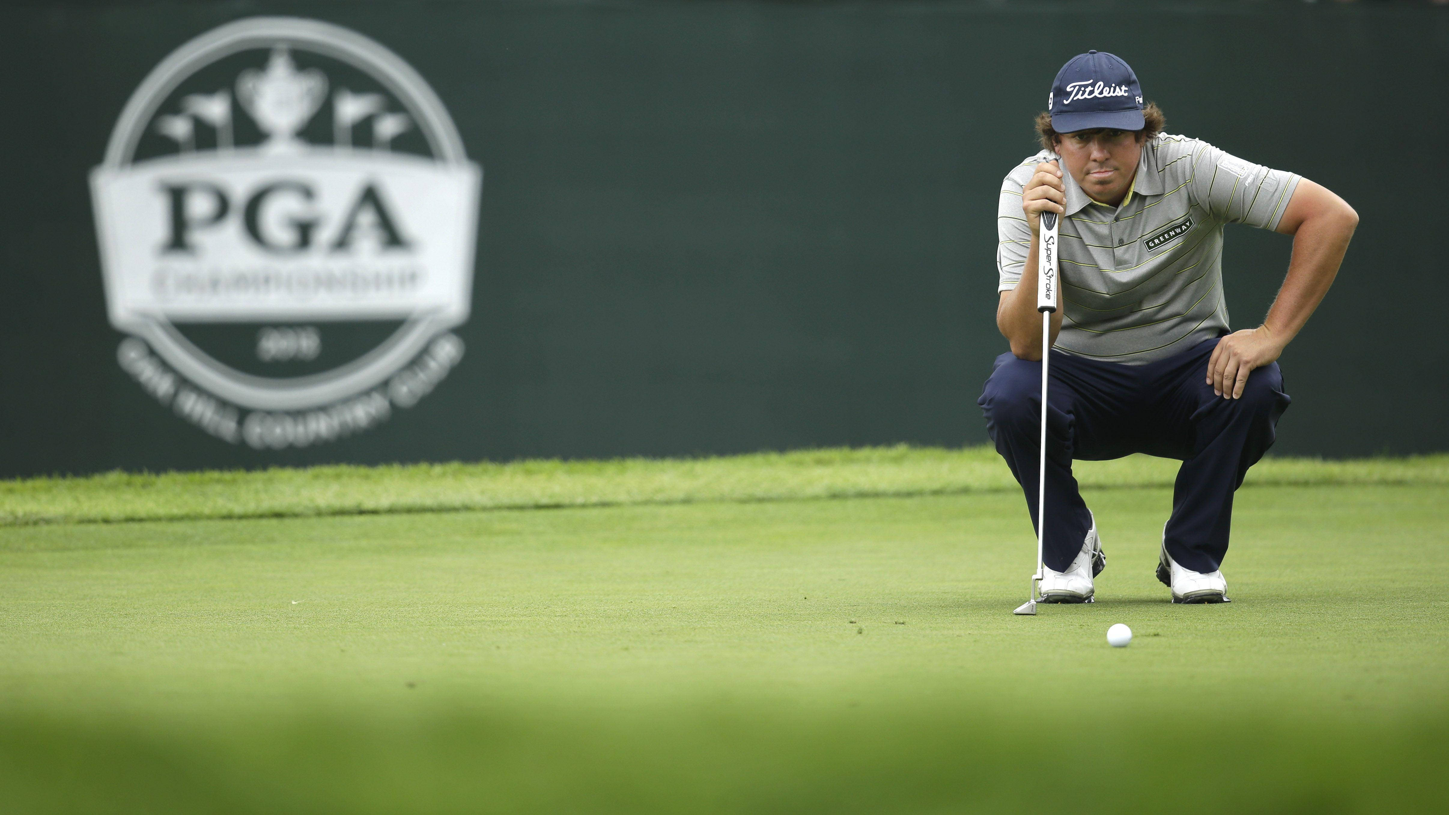 2013 PGA 比賽 杰森·杜夫納 壁紙 — 一位專注的高爾夫球手蹲在茂密的果嶺上，準備在PGA錦標賽中推入關鍵的一桿。
