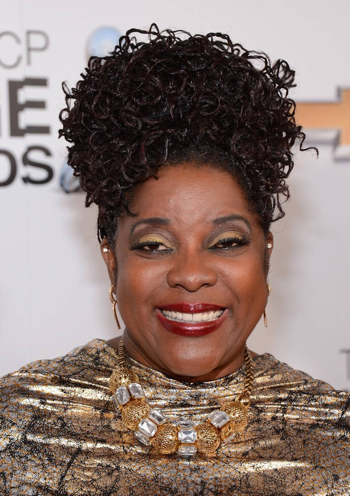 洛雷塔·迪文出席2013年第44屆NAACP影像獎 壁紙 — 一位光彩照人的女性，擁有豐盈的深色捲髮和大膽的紅唇，在華麗的頒獎典禮上燦爛微笑。