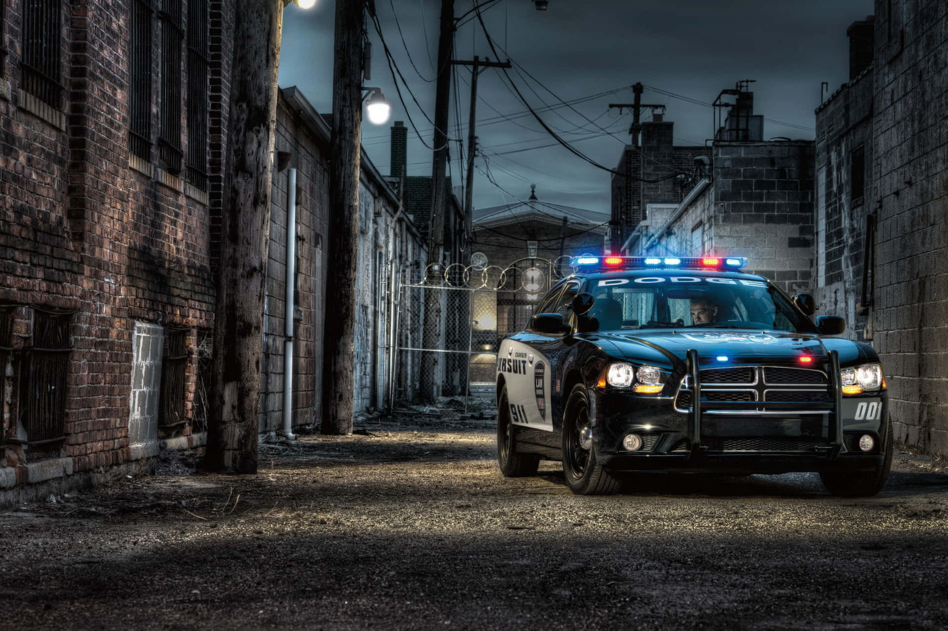夜晚黑暗城市後巷中閃著警燈的警車。