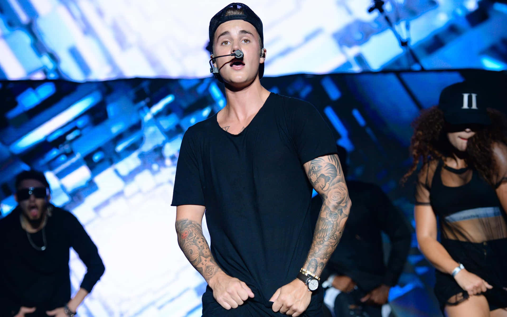 Justin Bieber 在演唱會中與舞者在舞台上唱歌。