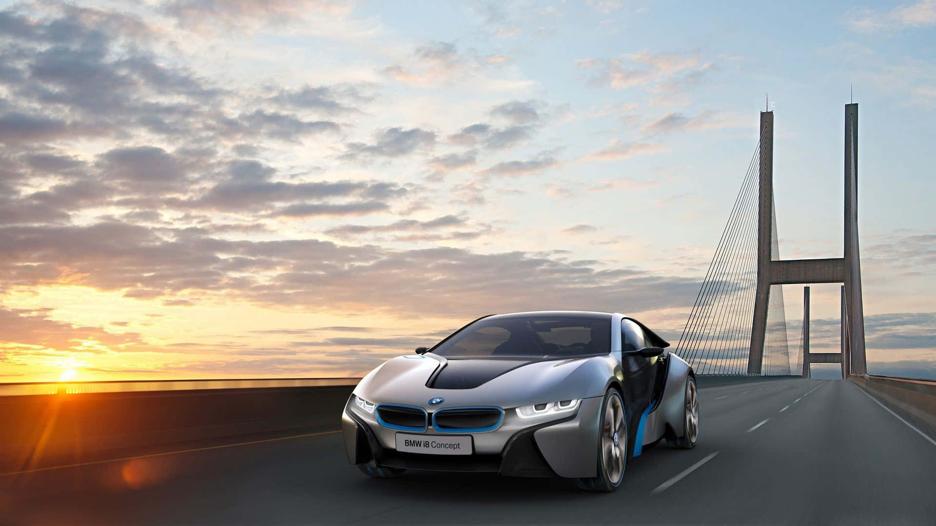 2017 BMW i8 桌面壁紙 壁紙 — 一輛時尚的銀色寶馬i8概念車在日落時分行駛在現代吊橋上，伴隨著金色的雲彩和發光的地平線。