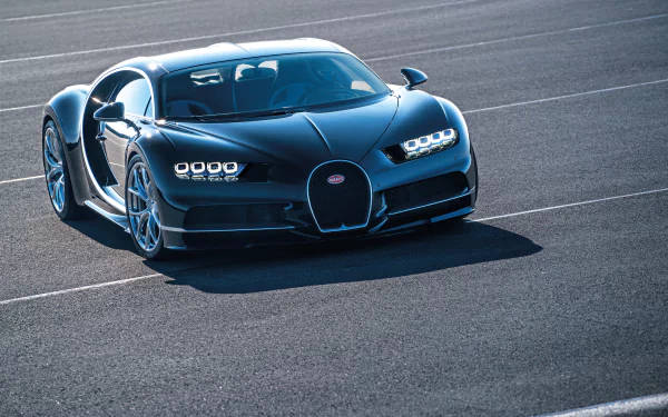 黑色Bugatti Chiron跑車停泊在瀝青賽道上，車門打開。