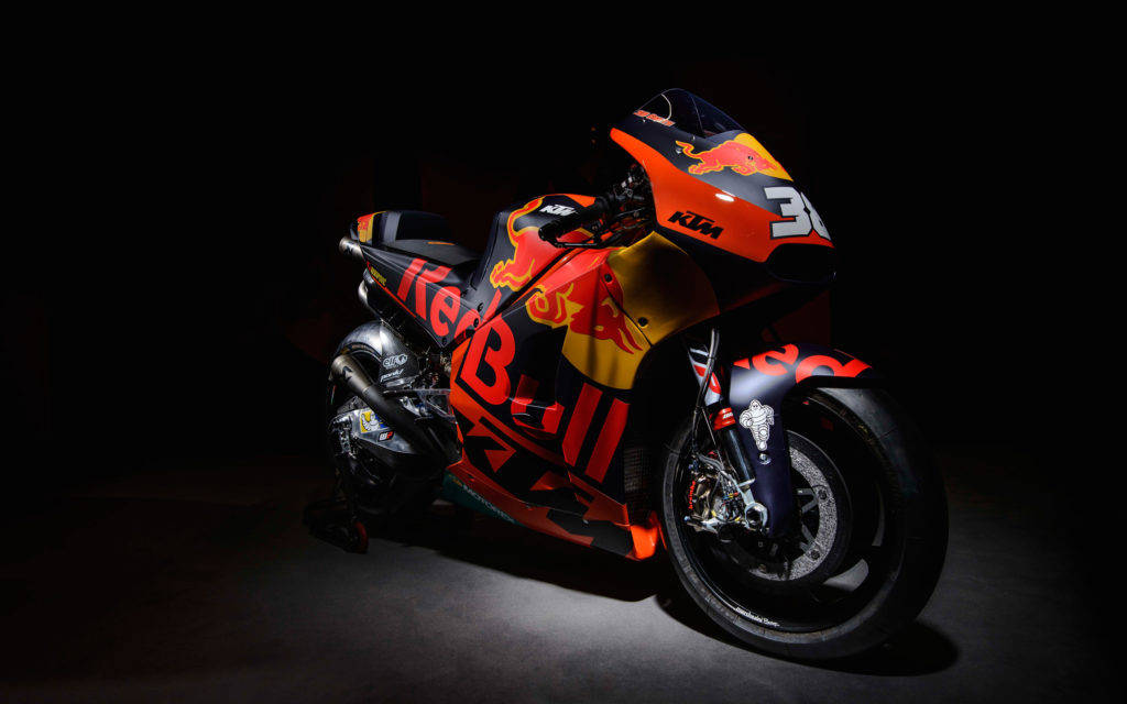 2017年MotoGP賽事中的RC16 KTM賽車 壁紙 — 一輛時尚的Red Bull KTM賽車摩托車，編號36，在黑色背景下被戲劇性地照亮。