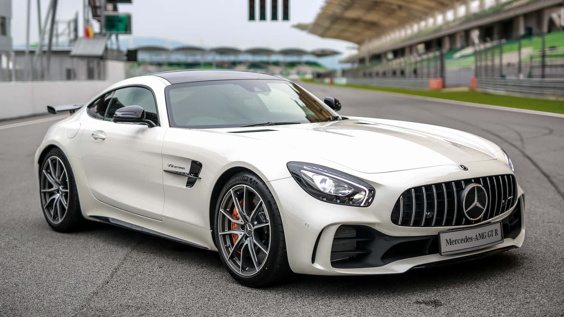 白色 Mercedes-AMG GT R 在賽道上，看台清晰可見。