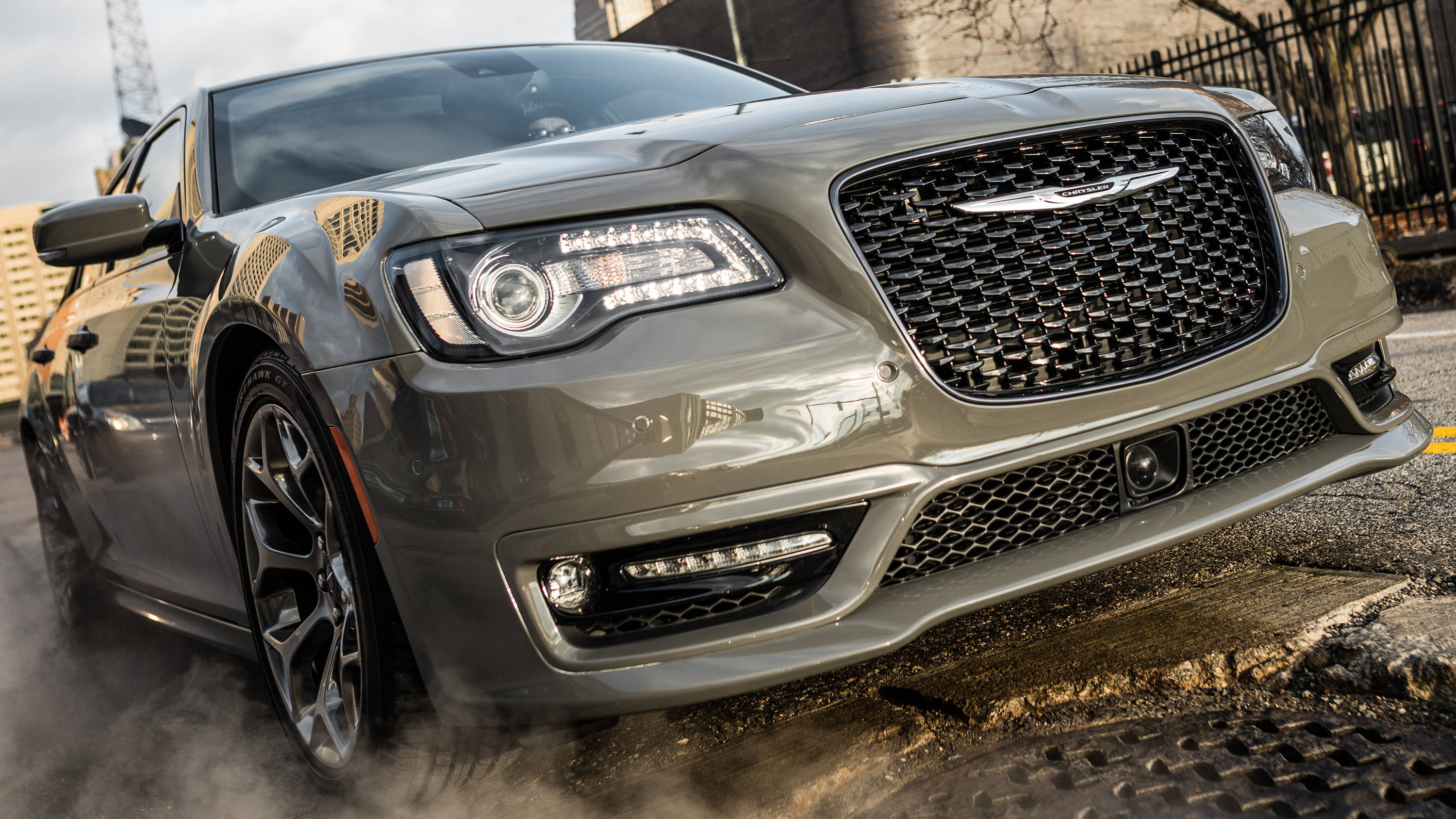 2018 Chrysler 轎車 壁紙 — 一架時尚的灰色Chrysler 300在潮濕的城市街道上進行燒胎，輪胎冒出滾滾濃煙。