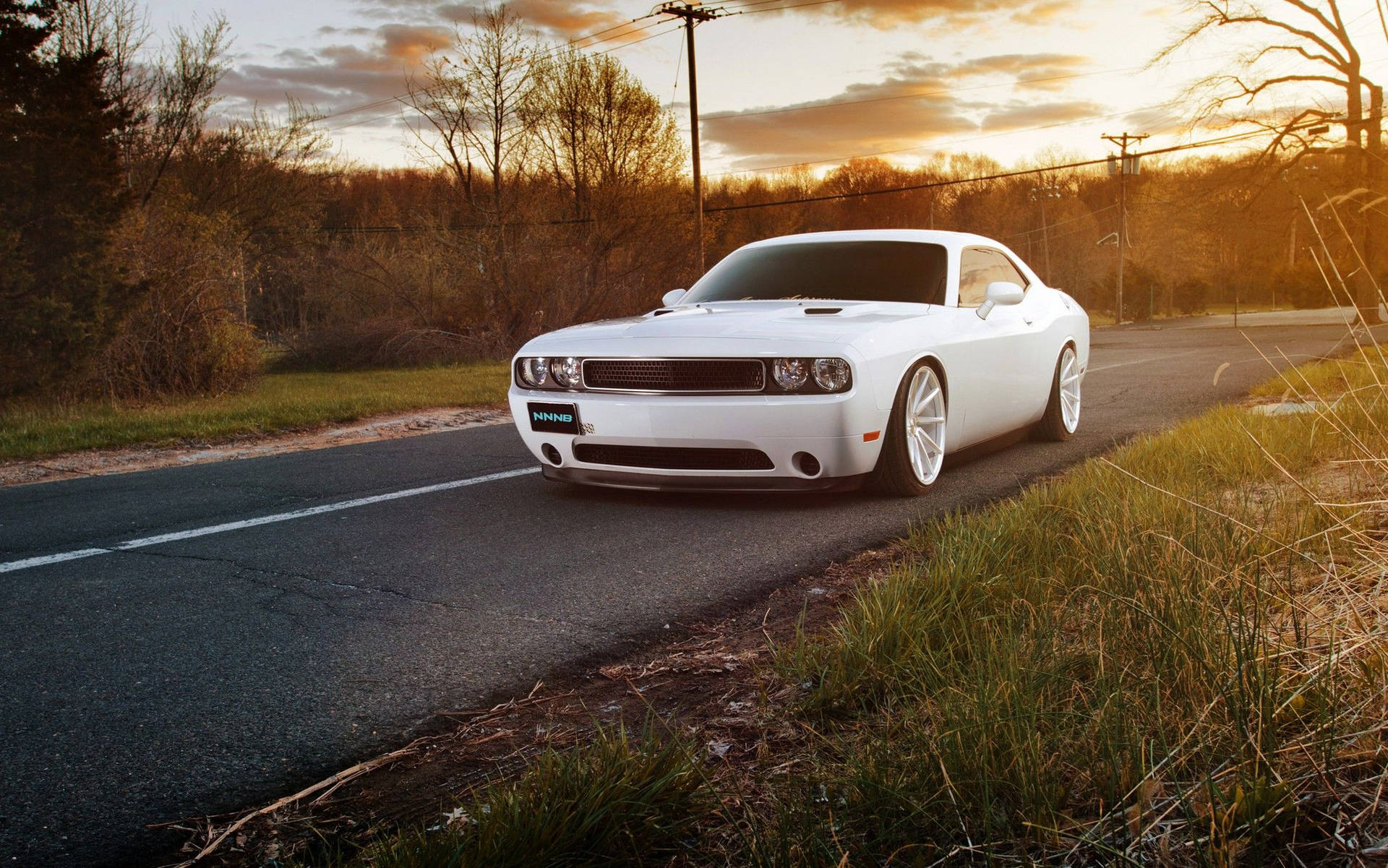 白色肌肉車在黃金時段停放在鄉村道路上。 — Dodge challenger GIF 壁紙