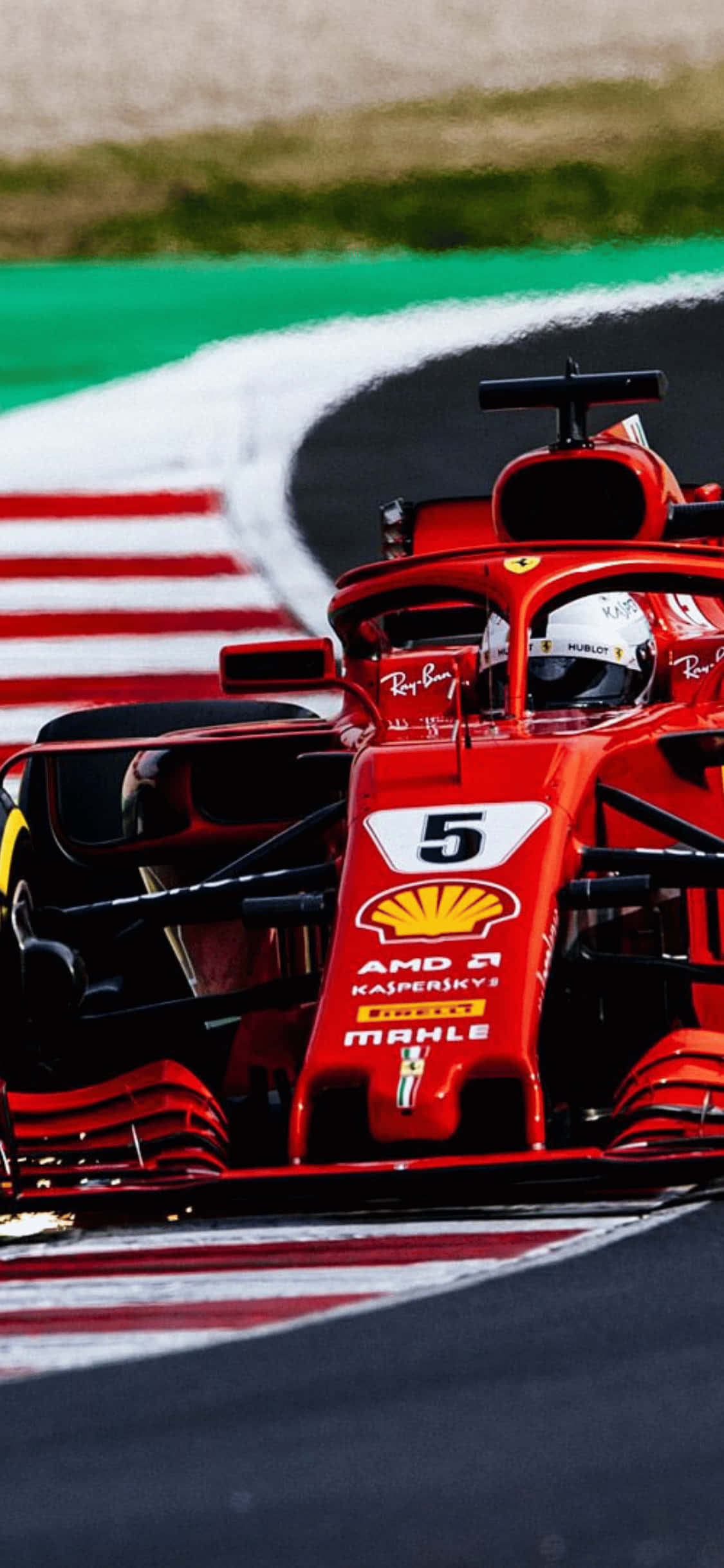 掌中即刻感受 2018 F1 賽事的熱血氛圍 壁紙 — 一輛紅色法拉利F1賽車，車號5，在由綠色和紅白路肩環繞的賽道上奔馳。