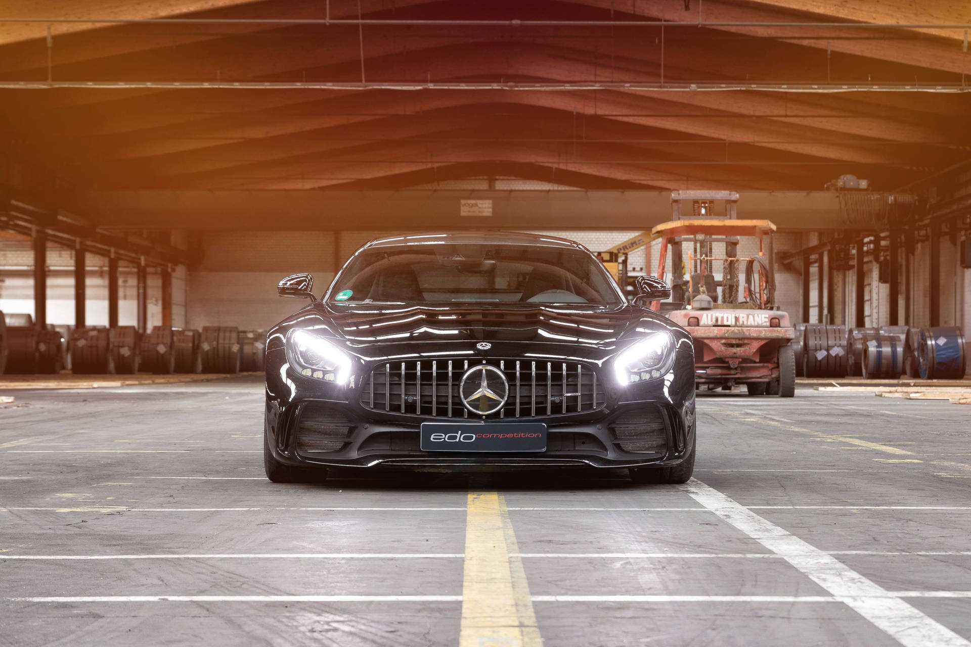 黑色Mercedes-AMG GT R停放在工業倉庫內，背景有叉車。