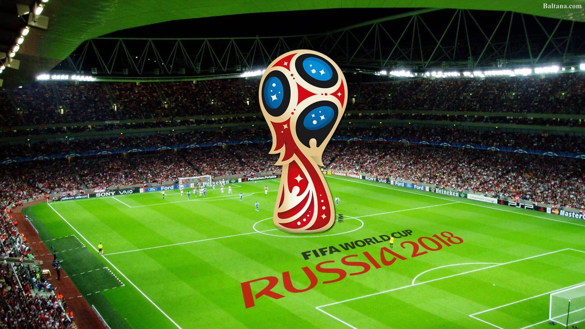 2018年俄羅斯世界盃現場 壁紙 — 一個巨大的FIFA世界盃獎盃矗立在充滿活力的綠色球場中央，周圍是擠滿觀眾的體育場看台，上方是明亮的泛光燈。