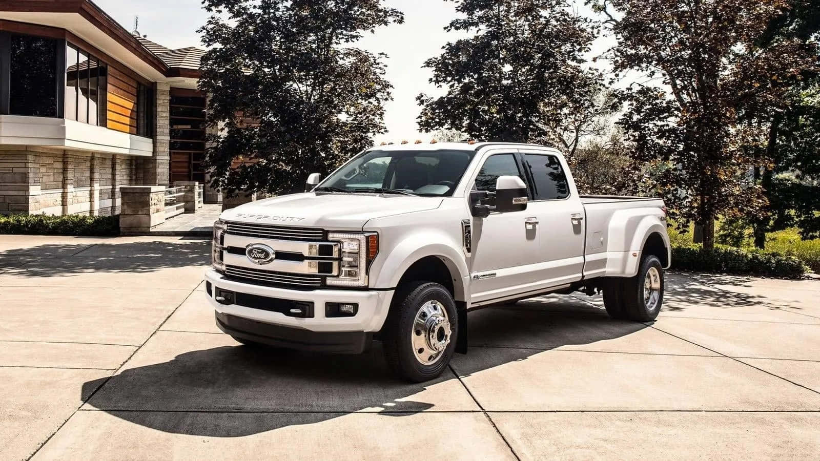 陽光明媚的日子裡，白色福特F-350貨車停在一棟現代化住宅前。